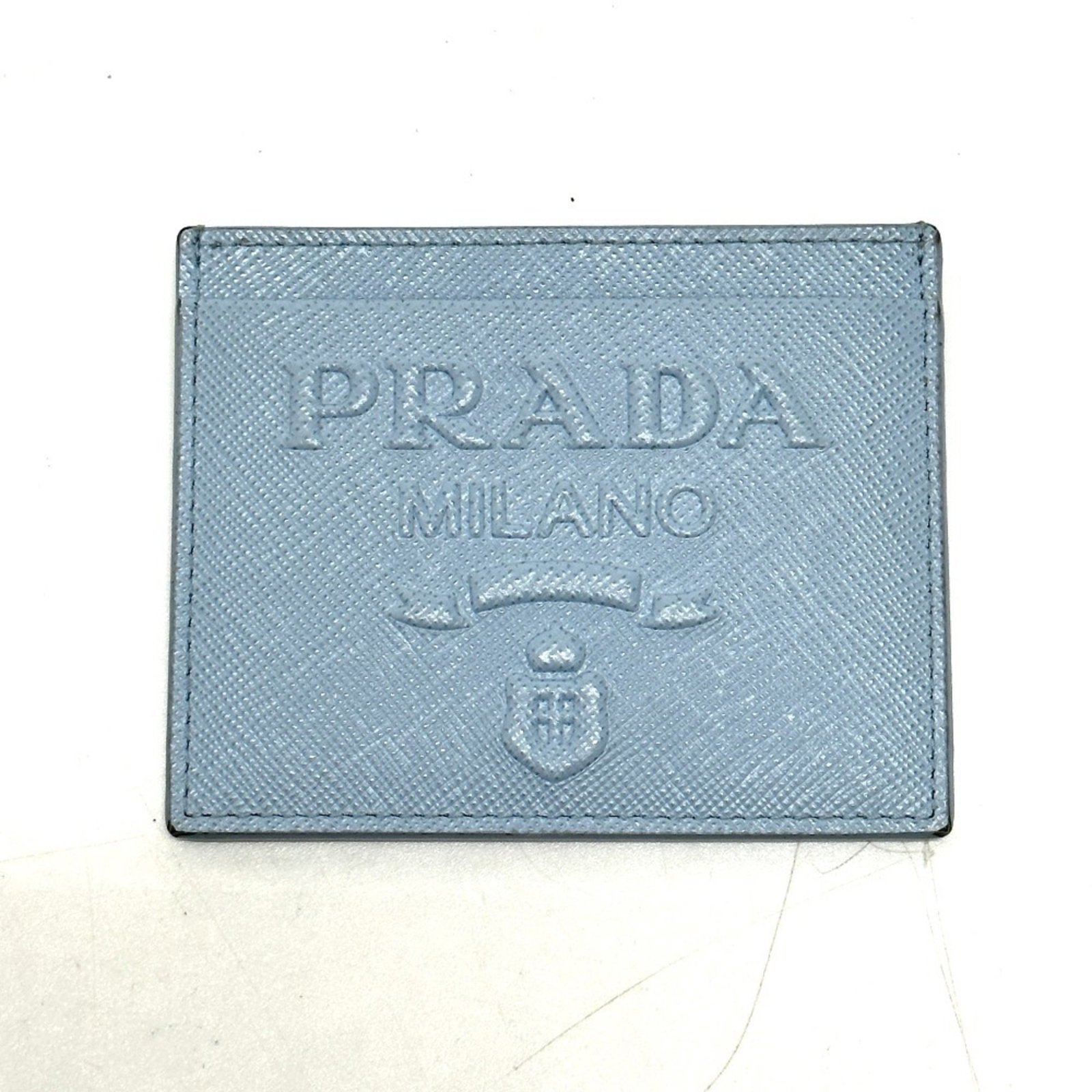 Prada Travel Pass Case: Prada Travel Pass Case The Prada Travel Pass Case is a stylish and functional accessory, measuring 8cm x 10cm with a light blue hue. It comes in a compact box, making it a convenient addition to any t