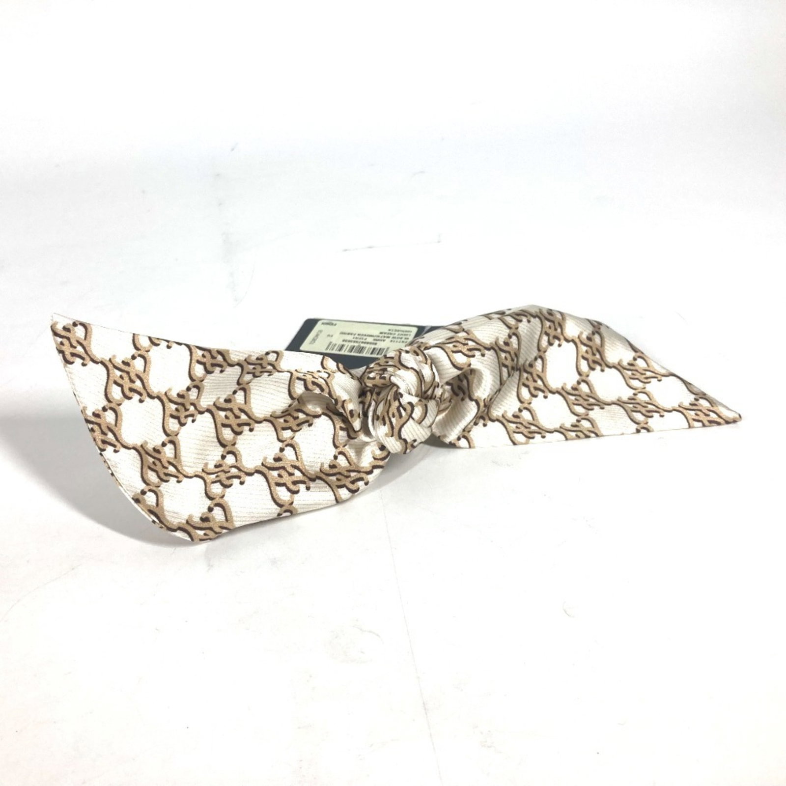 Fendi Silk Barrette: Fendi Silk Barrette Silk fabric and a sleek design make this Fendi barrette a stylish accessory. The beige color and 19cm x 7.48'' size provide a versatile and elegant look. The item comes in a box fo