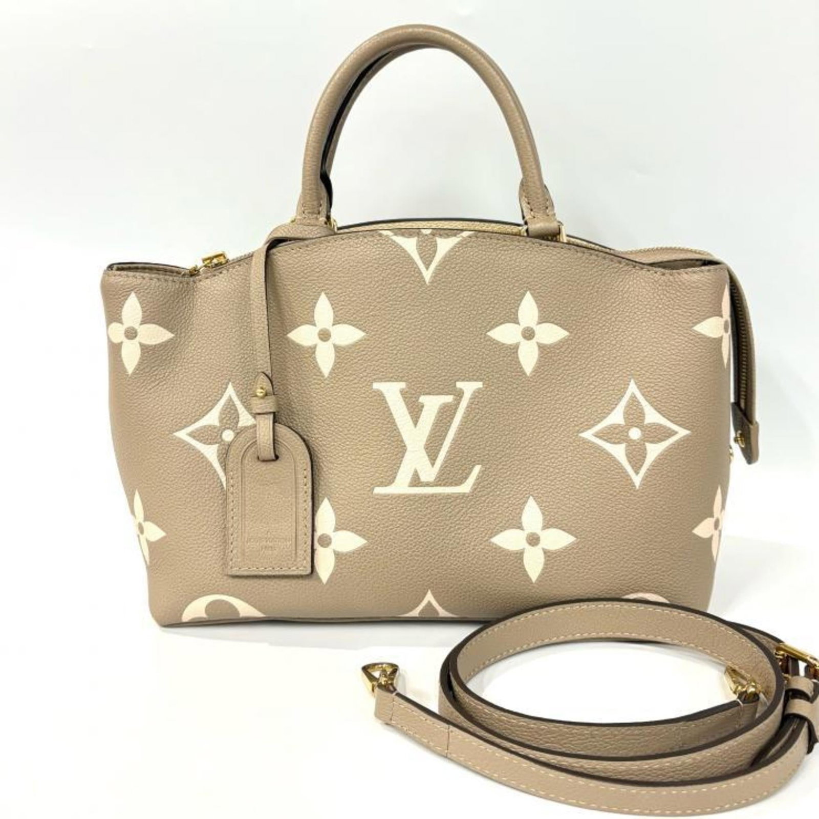 Handbag Louis Vuitton Monogram Empreinte: Handbag Louis Vuitton Monogram Empreinte The Louis Vuitton Monogram Empreinte handbag boasts a timeless design with its iconic beige, ivory, and tourterelle colors. Measuring 21cm x 29cm x 12cm, this