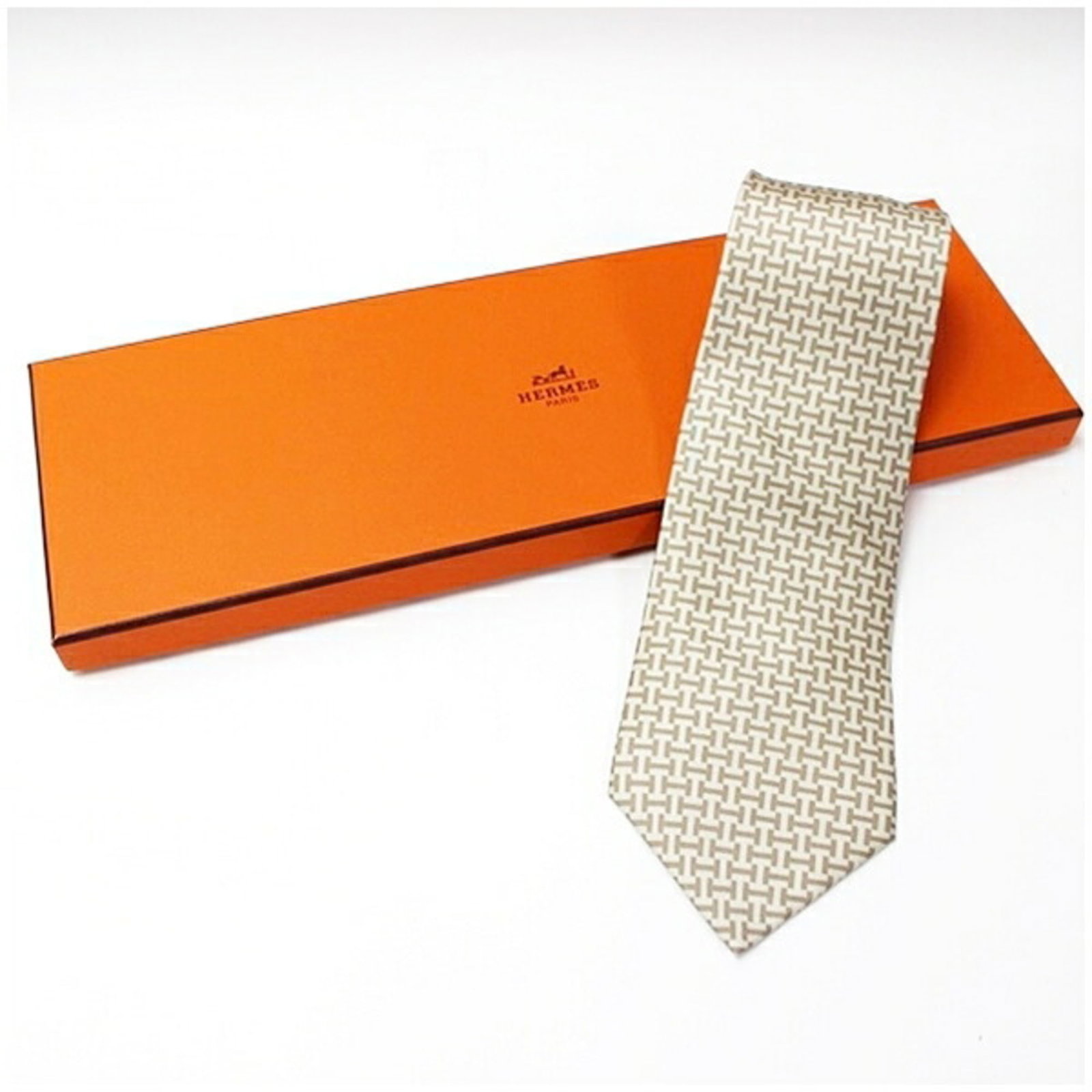 Silk Cravat Hermes: Silk Cravat Hermes Silk cravat from Hermes, made from high-quality silk with a width of 9cm. This cravat is available in beige and light brown colors, offering a versatile accessory for men and women.