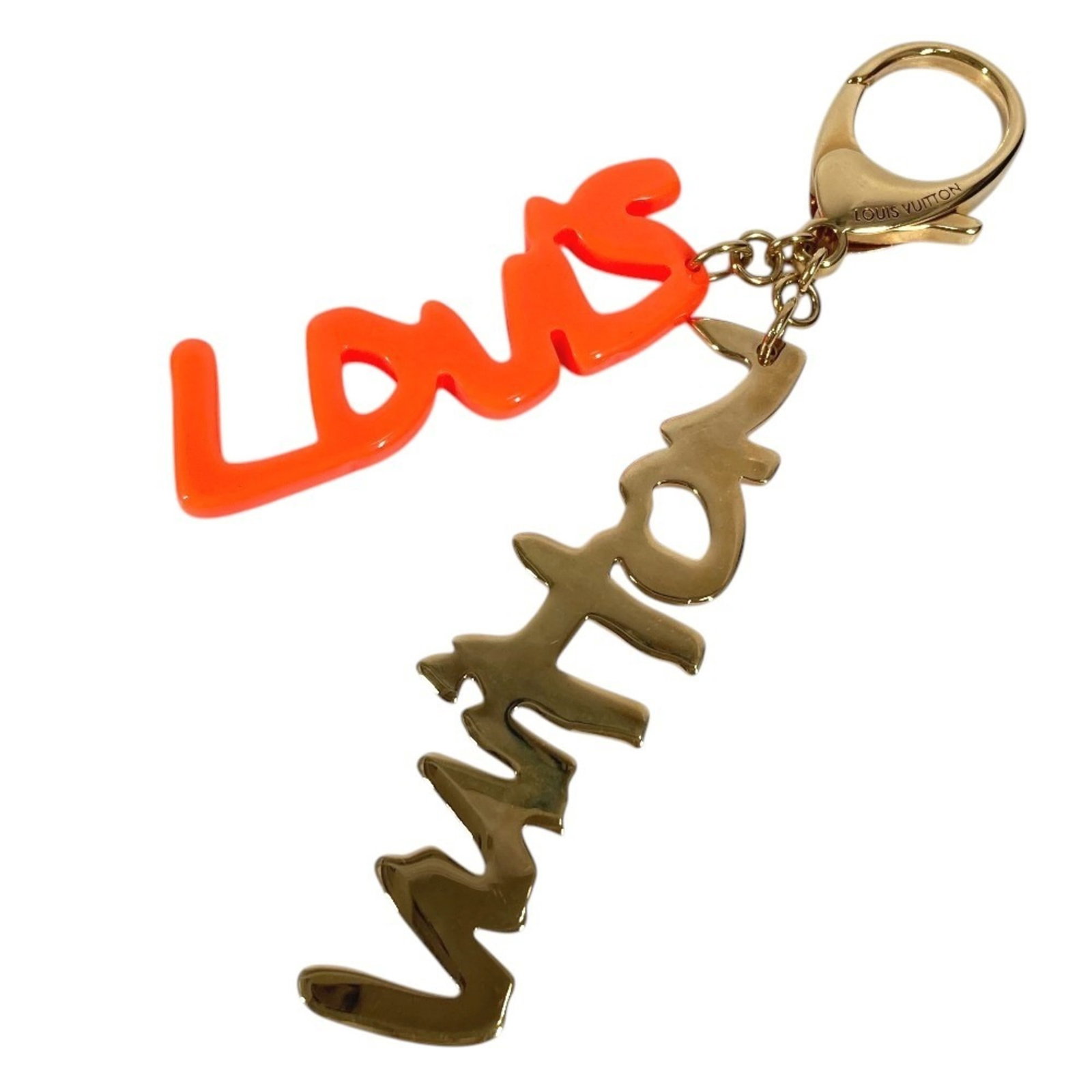 Metal Keyring Plastic Louis Vuitton: Metal Keyring Plastic Louis Vuitton Metal Keyring Plastic Louis Vuitton features a gold and orange design, combining metal and plastic materials. The keyring bears a signature, a notable detail of