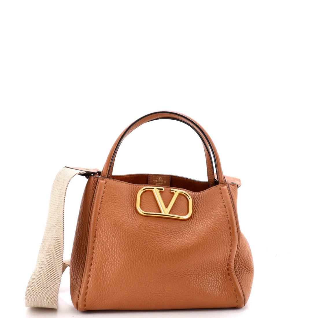 Garavani Valentino Alltime Medium Leather Tote: Garavani Valentino Alltime Medium Leather Tote The Garavani Valentino Alltime Medium Leather Tote boasts a rich, brown leather exterior with a sleek, medium size. This stylish tote features a suede
