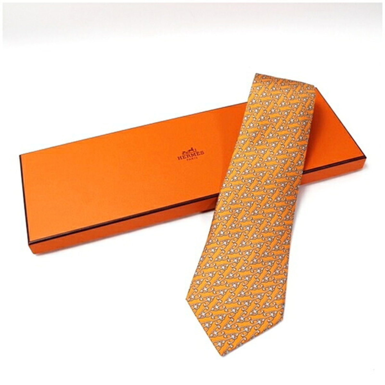 Silk Cravat Hermes: Silk Cravat Hermes Silk Cravat in vibrant orange, crafted from luxurious silk, measures 9.5cm in width. Made by the renowned French fashion house Hermes, this cravat is a statement piece for any occas