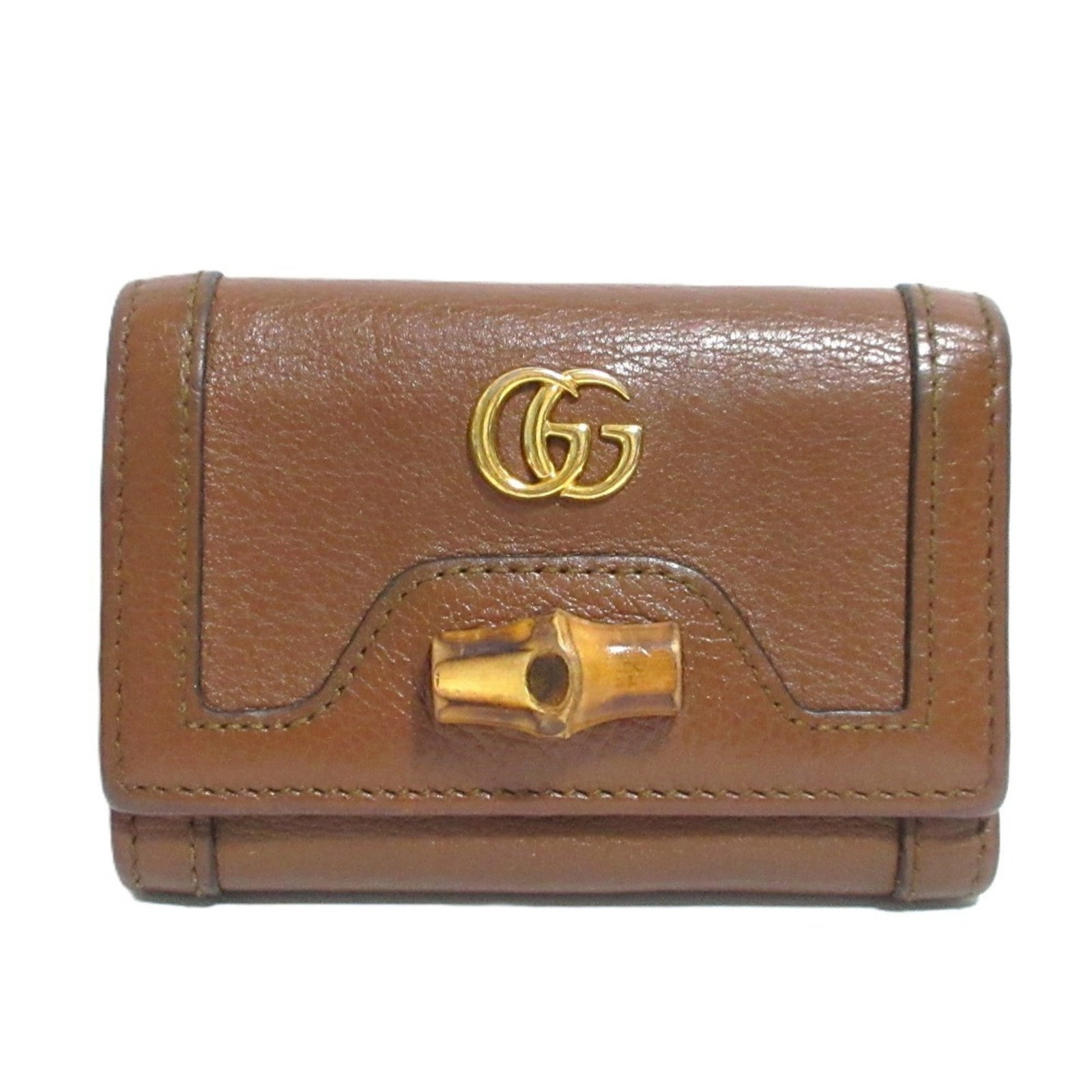 Gucci Wallet (Tri-Fold): Gucci Wallet (Tri-Fold) The Gucci Tri-Fold Wallet in Brown features a classic design with a sturdy bamboo construction, providing a natural and elegant touch. Measuring 7.5cm x 10.5cm x 3cm, this