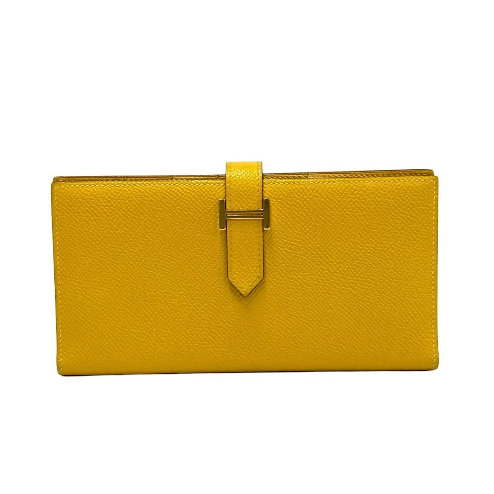 Epsom Leather Bi fold Wallet Hermes: Epsom Leather Bi fold Wallet Hermes Epsom leather, a rich and vibrant material, is used to craft this bi-fold wallet from the iconic Hermes brand. The wallet's long design and yellow color make it a