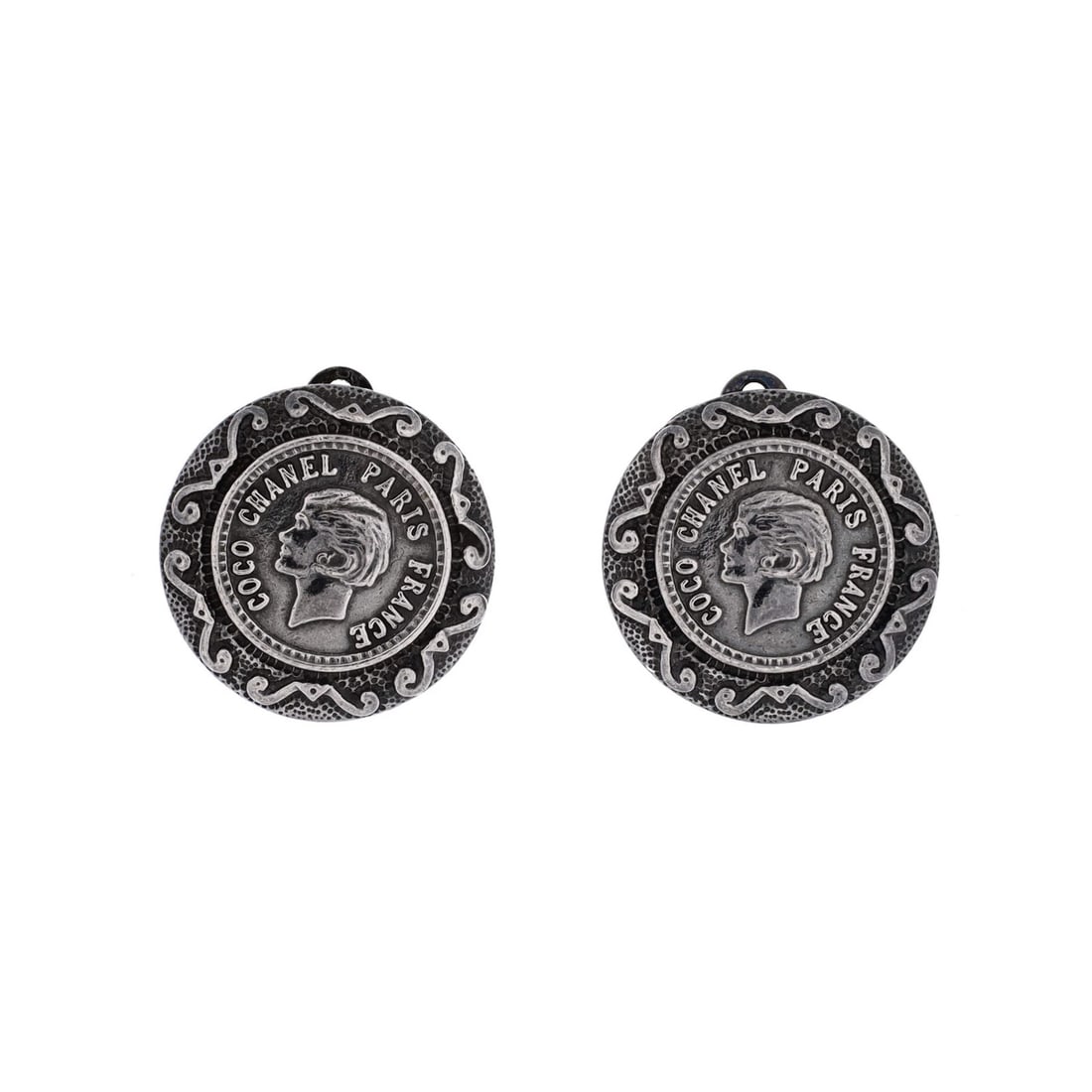 Coco Chanel Round Figure Clip On Earrings Metal: Coco Chanel Round Figure Clip On Earrings Metal Silver Coco Chanel Round Figure Clip-On Earrings with scratches and tarnish, measuring 0.85" in height and width, bearing a signature. Made of metal,