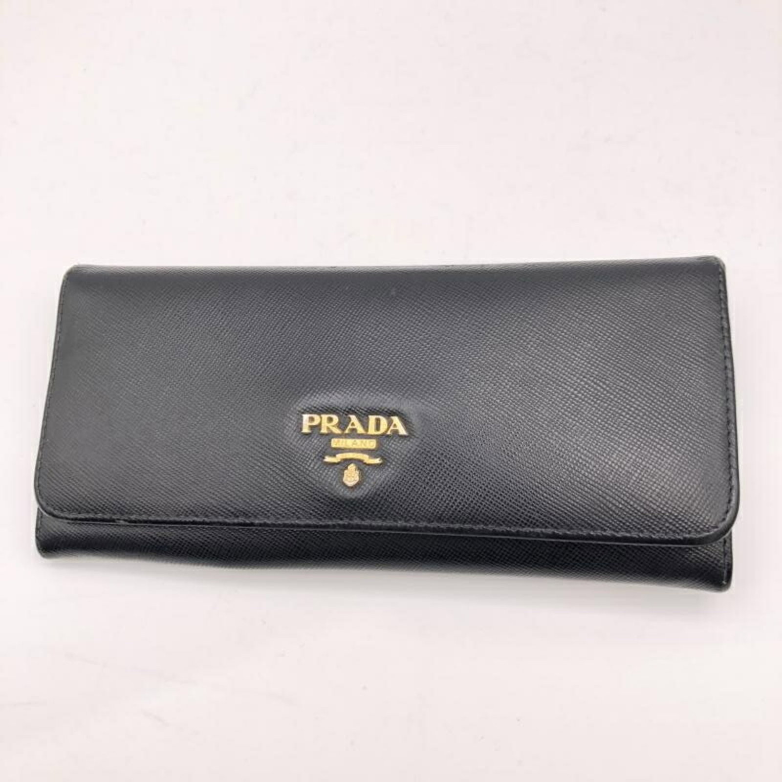 Double Long Wallet In Black By Prada Saffiano: Double Long Wallet In Black By Prada Saffiano Double Long Wallet In Black By Prada Saffiano, a sleek and sophisticated accessory, measures 9cm x 18.8cm in size, featuring a classic design with a durab