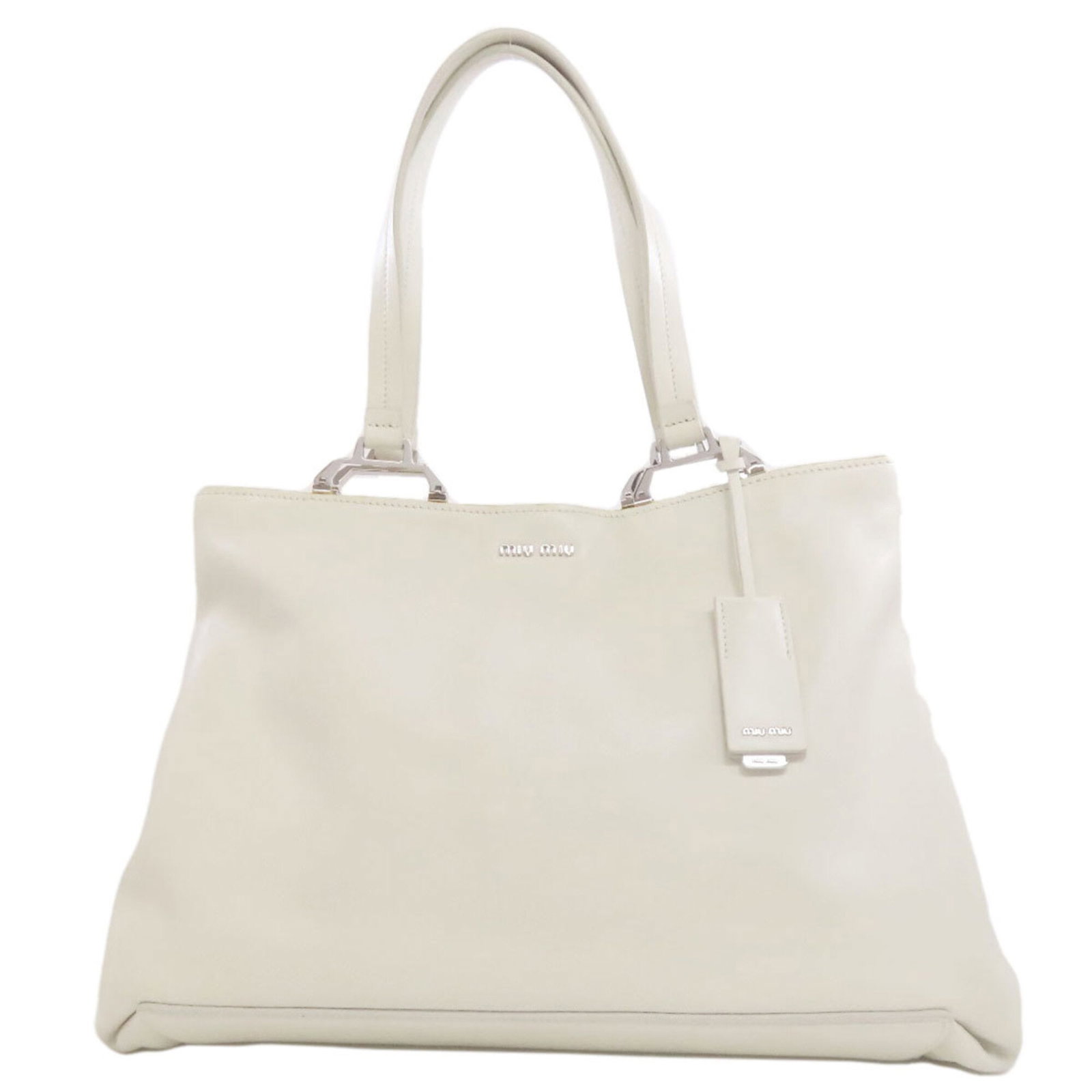 Miu Tote Bag Leather: Miu Tote Bag Leather The Miu Miu Tote Bag Leather is a stylish and elegant accessory made from high-quality calfskin leather, available in a crisp white color. This classic tote bag features a