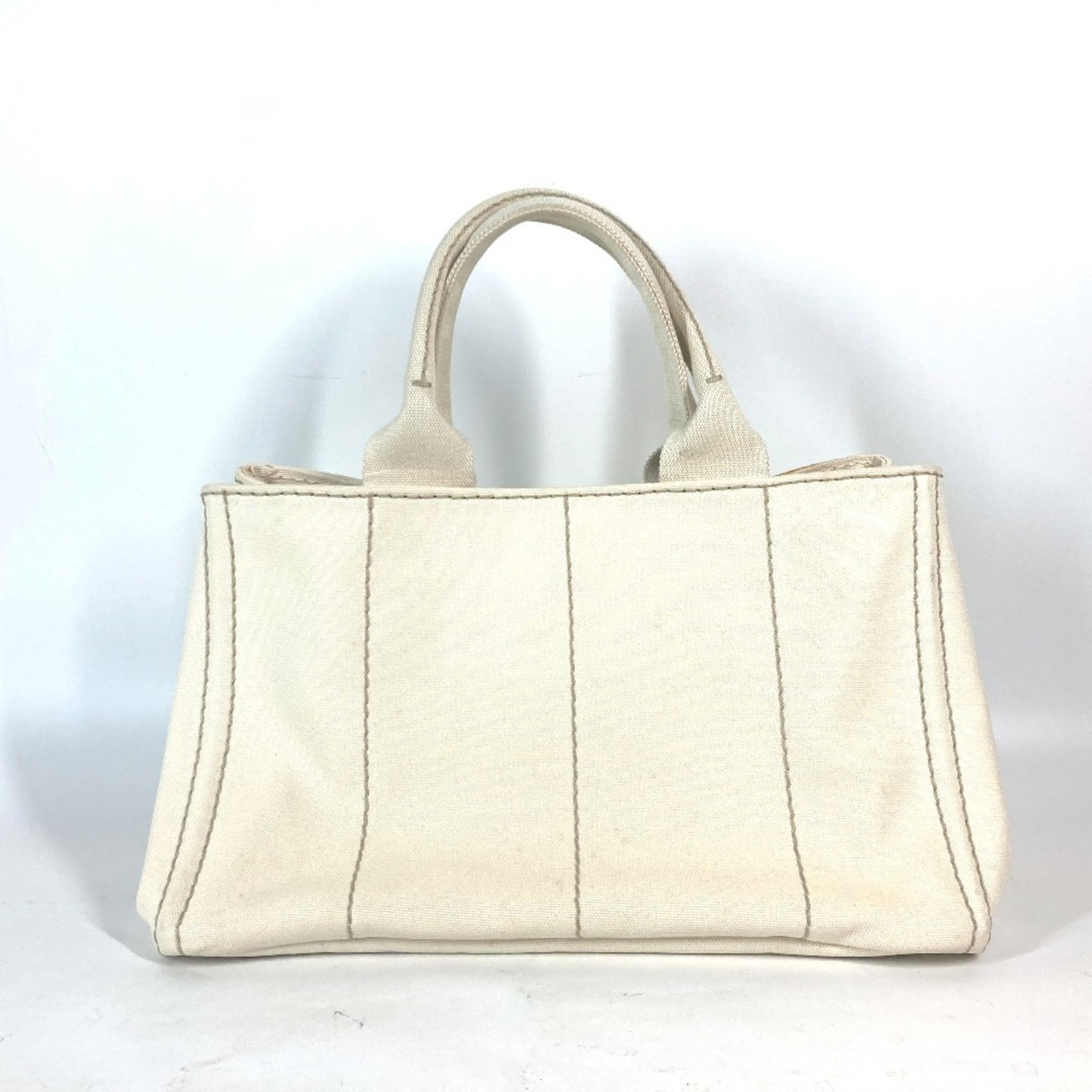 Canvas tote bag Prada handbag: Canvas tote bag Prada handbag Canvas tote bag with a Prada handbag. This ivory canvas tote bag bears a signature and is accompanied by a guarantee card. Measuring 21cm x 33.5cm x 20.5cm, it features