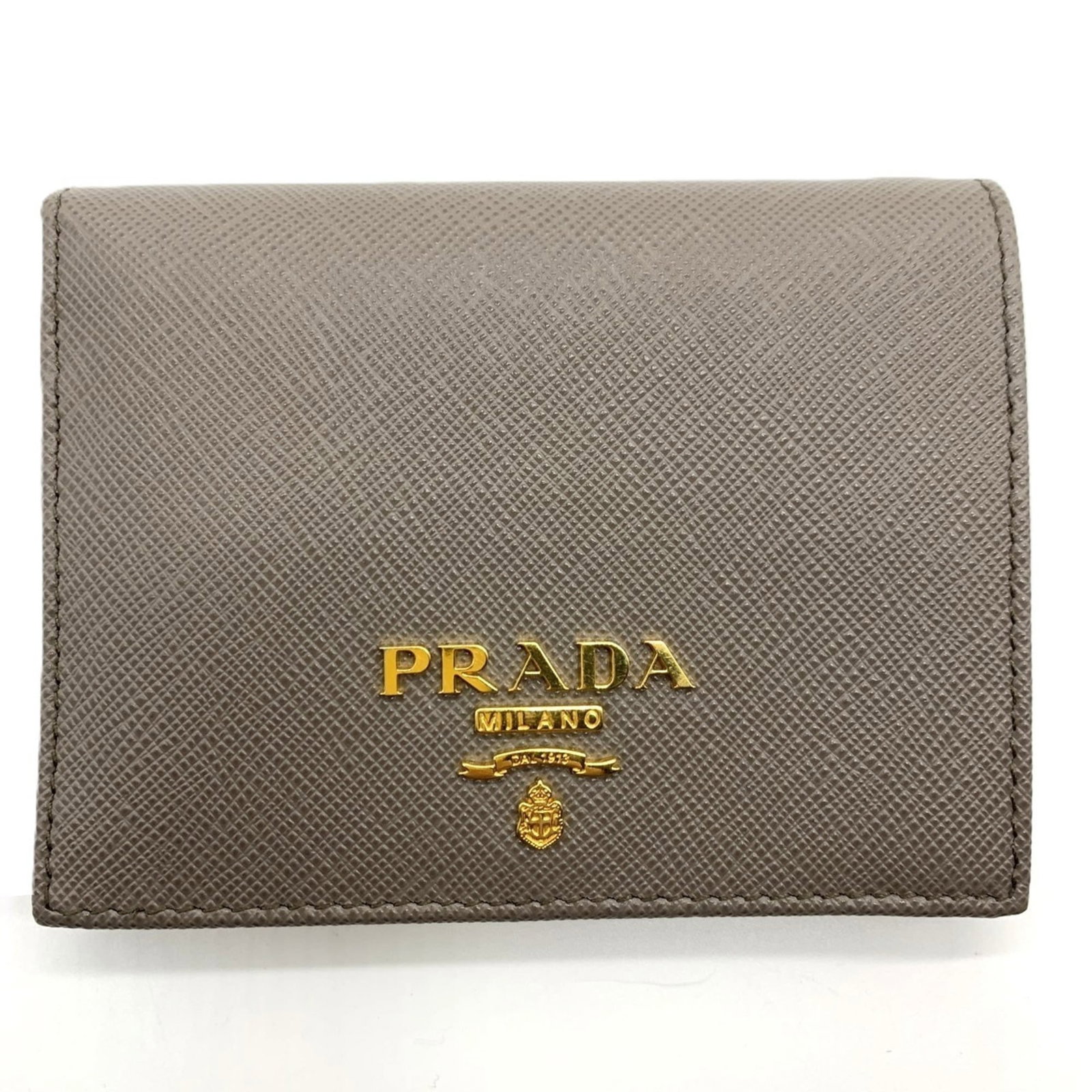 Prada Wallet (Bi-Fold) Saffiano: Prada Wallet (Bi-Fold) Saffiano Saffiano leather gives this bi-fold Prada wallet a sleek, sophisticated look. The interior features multiple slots for cards and cash, while the snap fastener closure e