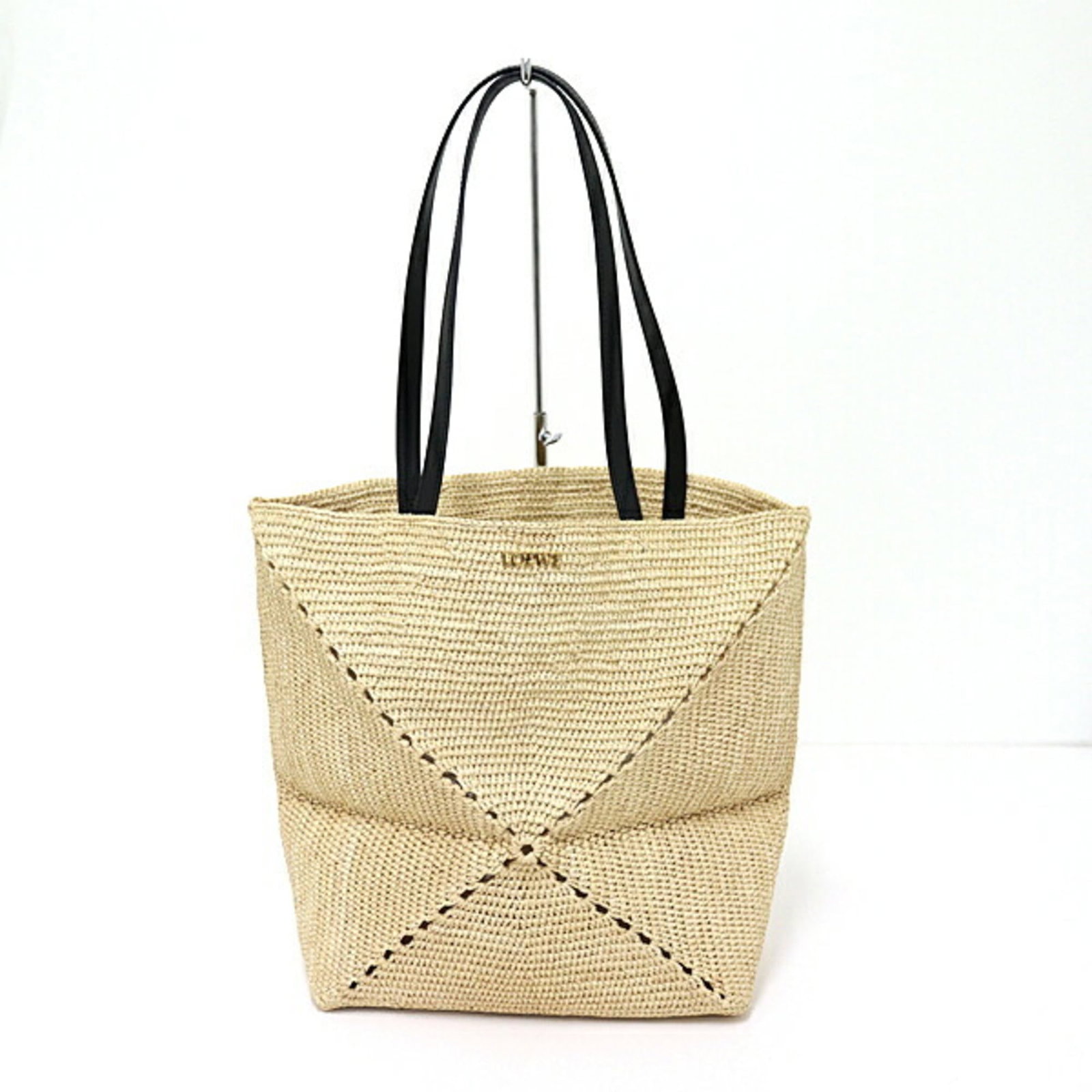 Raffia Leather Loewe Tote: Raffia Leather Loewe Tote Raffia and leather come together in this unique Loewe tote, featuring a distinctive calfskin material and open closure. The bag's natural colors and textures are showcased in