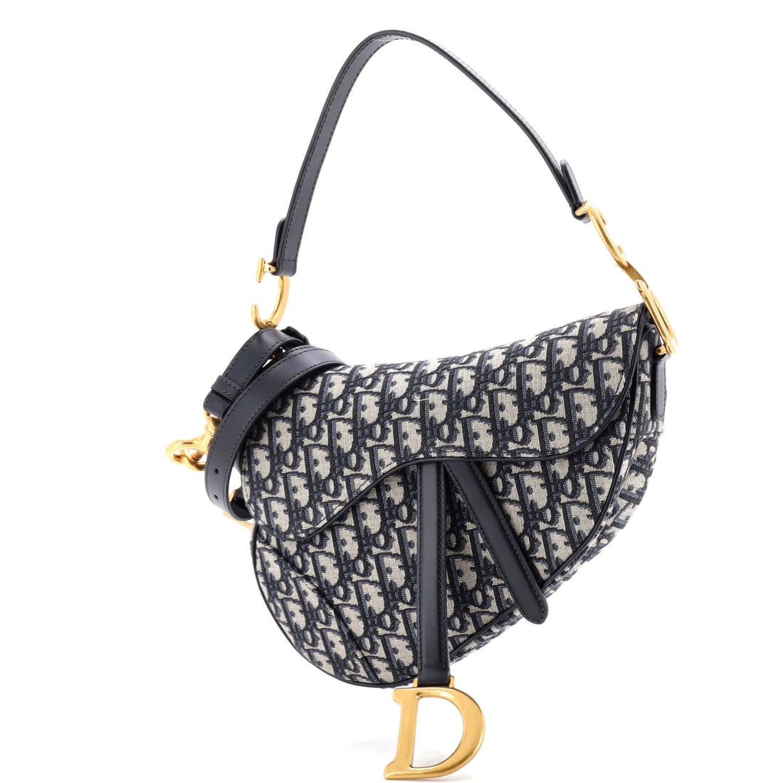 Saddle Handbag Strap Oblique Canvas Medium Christian Dior: Saddle Handbag Strap Oblique Canvas Medium Christian Dior Saddle Handbag with Strap Oblique Canvas Medium from Christian Dior features a striking blue canvas exterior with oblique design, showcasing