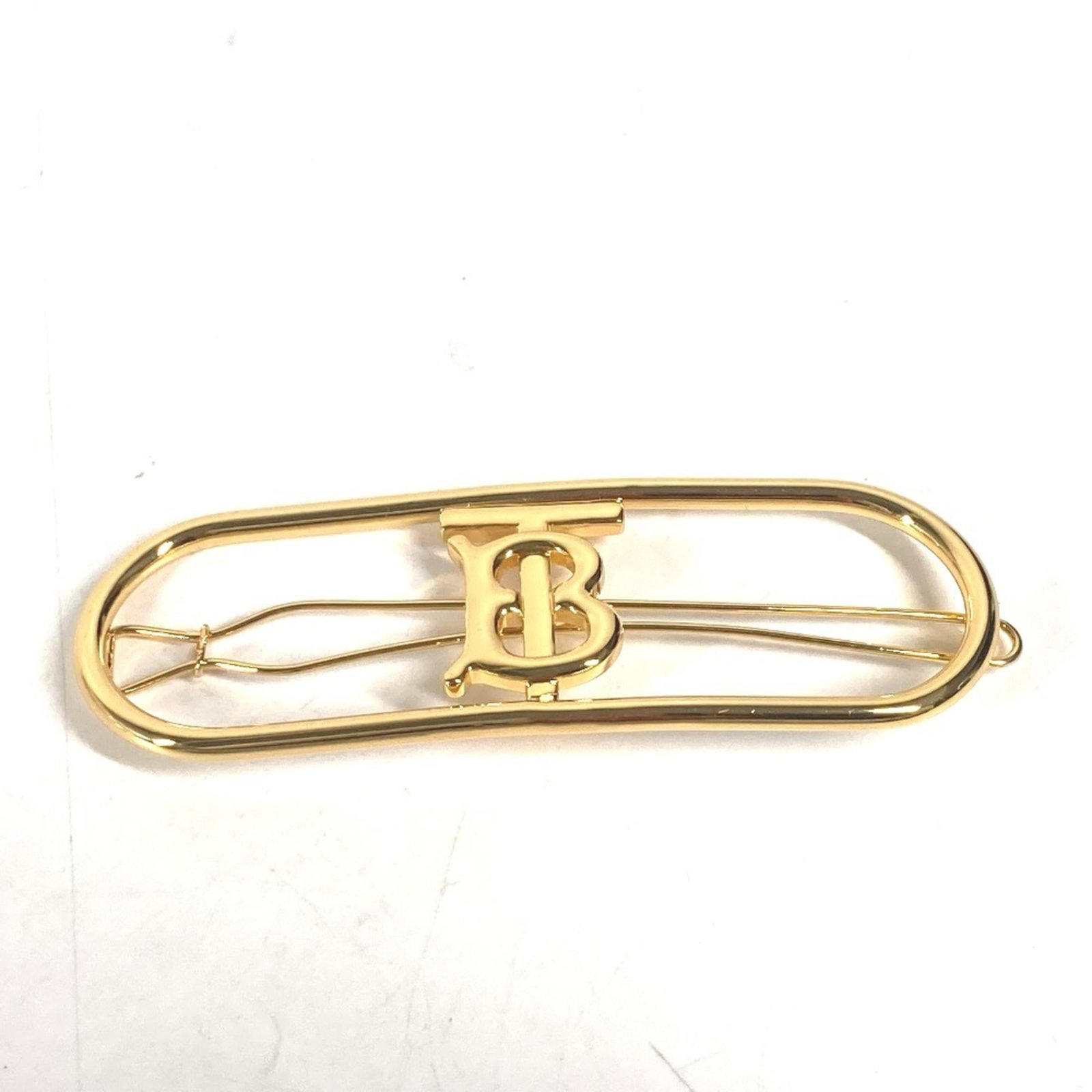 Metal Barrette Burberry: Metal Barrette Burberry A gold metal barrette bearing the iconic Burberry TB logo, measuring 3cm x 8.5cm. This metal barrette is a hair pin accessory made from metal material. Item Specifics: Brand: