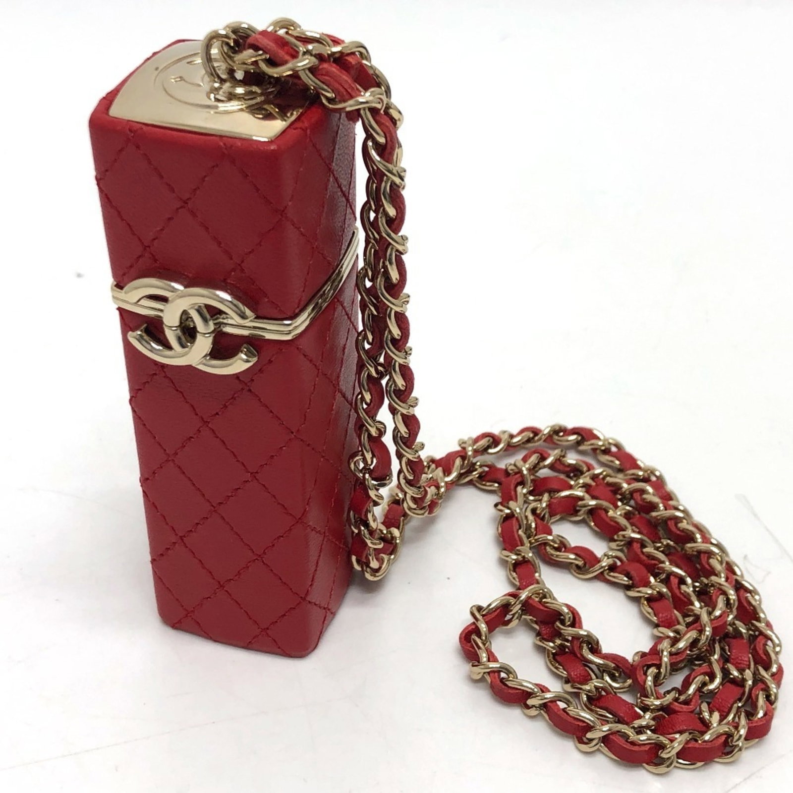 Leather Lipstick Case by Chanel: Leather Lipstick Case by Chanel This luxurious leather lipstick case is a vibrant red color, measuring 10cm x 3.5cm. It comes with a box and dust bag, making it a complete and stylish accessory. The