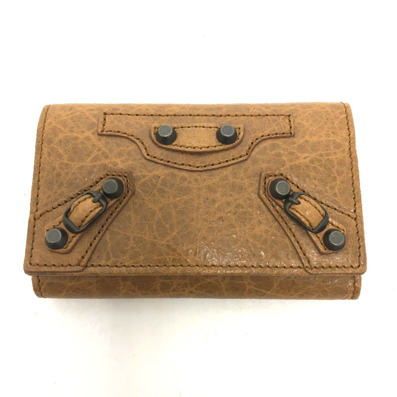 Keycase Leather by Balenciaga: Keycase Leather by Balenciaga Keycase Leather by Balenciaga is a sleek, brown leather keycase with a compact design, measuring 10.5cm x 6.5cm x 1.5cm. The leather material provides a durable and