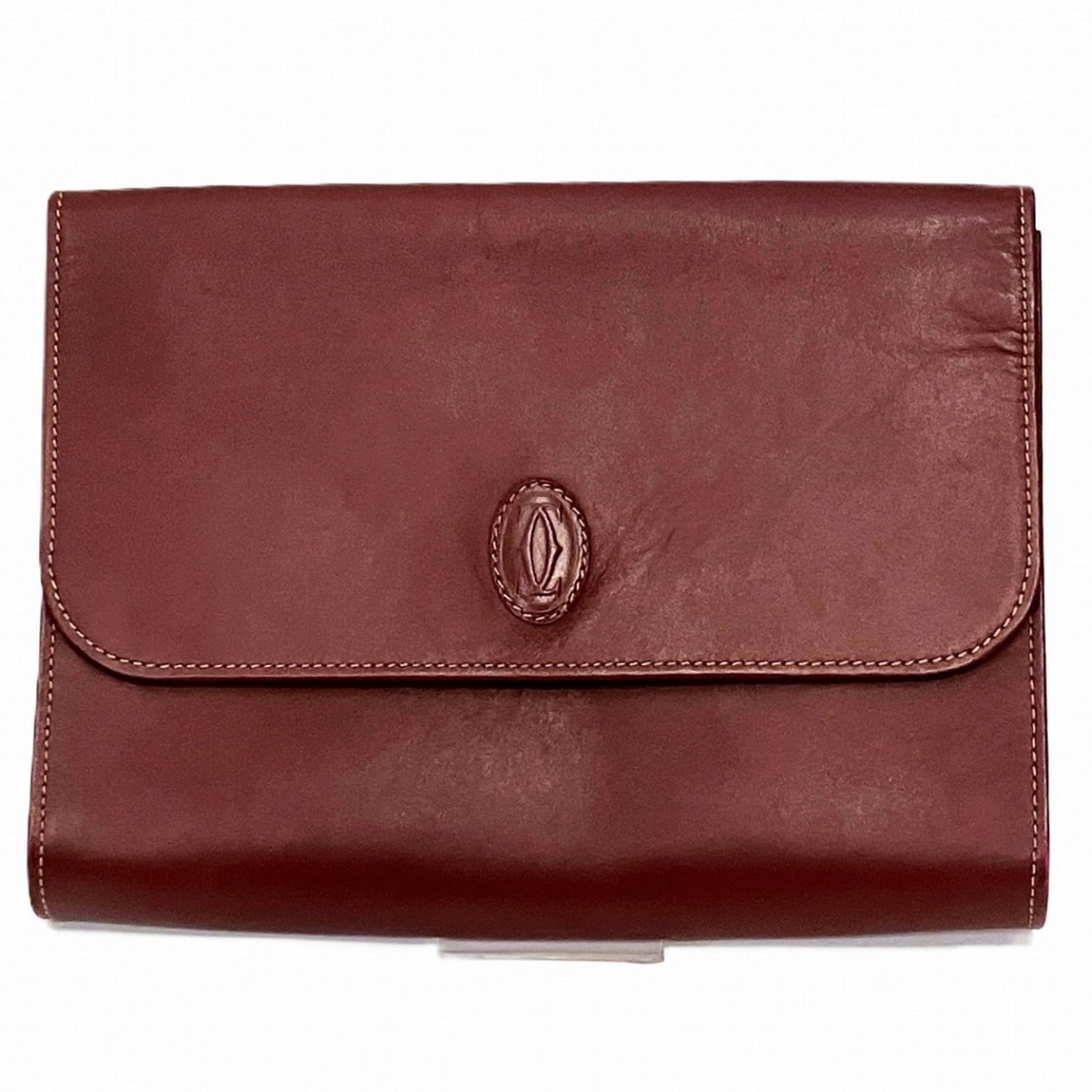 Cartier Clutch Bag Leather: Cartier Clutch Bag Leather Wine red leather Cartier clutch bag with a sleek design and a magnetic closure. This stylish accessory measures 19.5cm x 26cm x 4cm and features a compact size perfect for