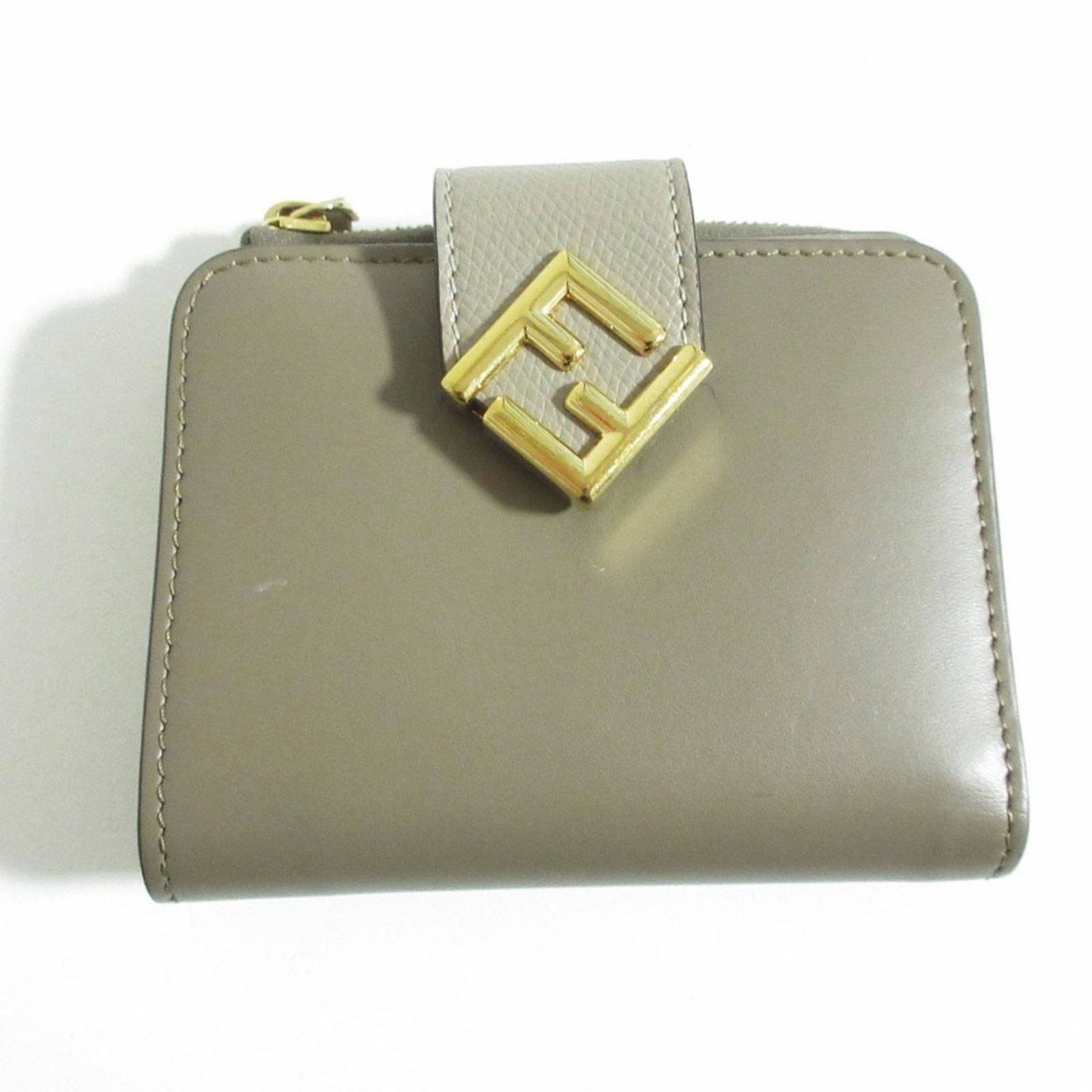 Bi fold wallet: Bi fold wallet The Fendi bi-fold wallet boasts a sleek, beige design with clean lines, measuring 8.5cm x 11cm x 2.5cm. Its compact size makes it easy to carry, while its classic style ensures it will