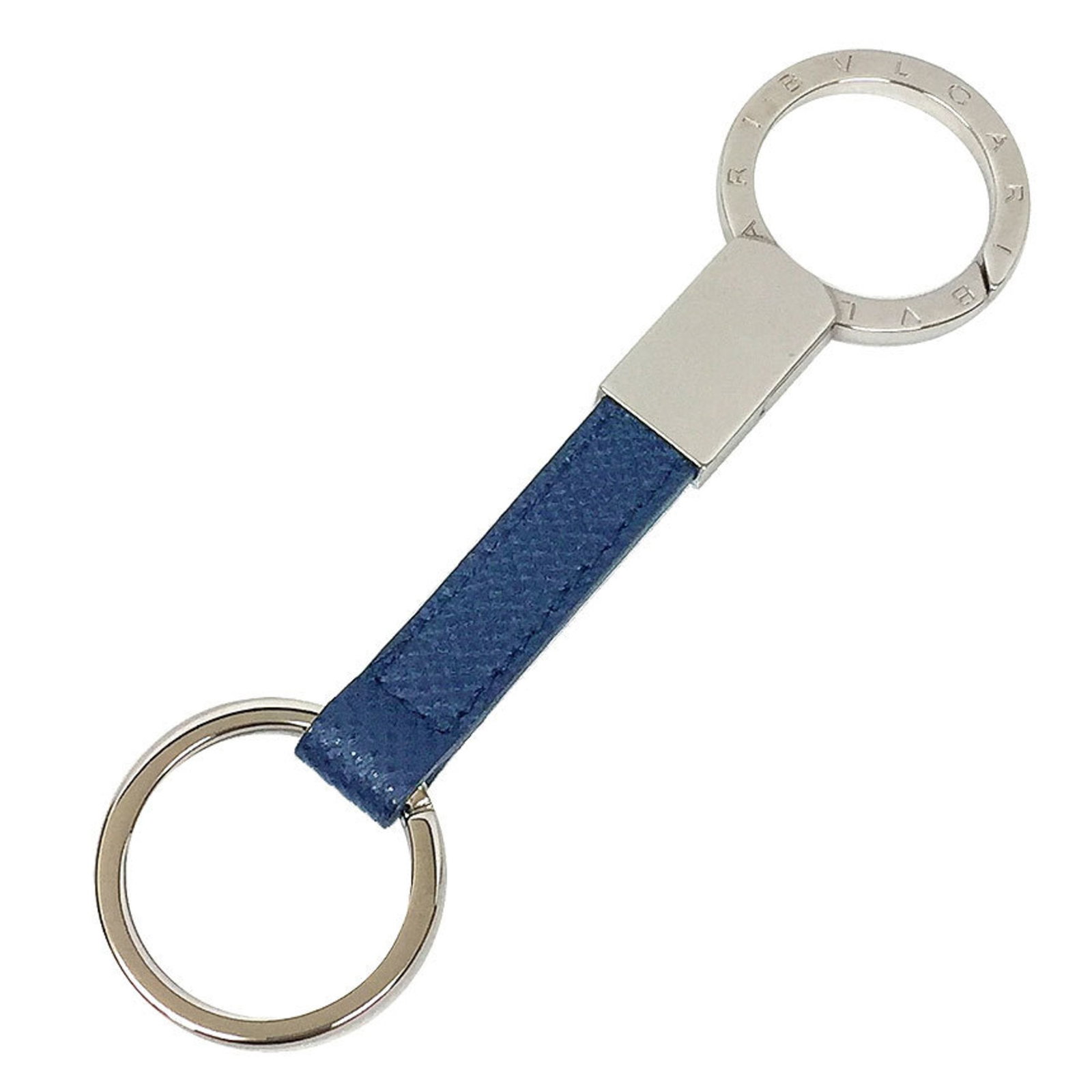 Keyring Brass Leather Bvlgari: Keyring Brass Leather Bvlgari Brass and leather come together in a sleek keyring from Bvlgari, available in navy and silver. The keyring is made from brass and features a leather accessory, presented