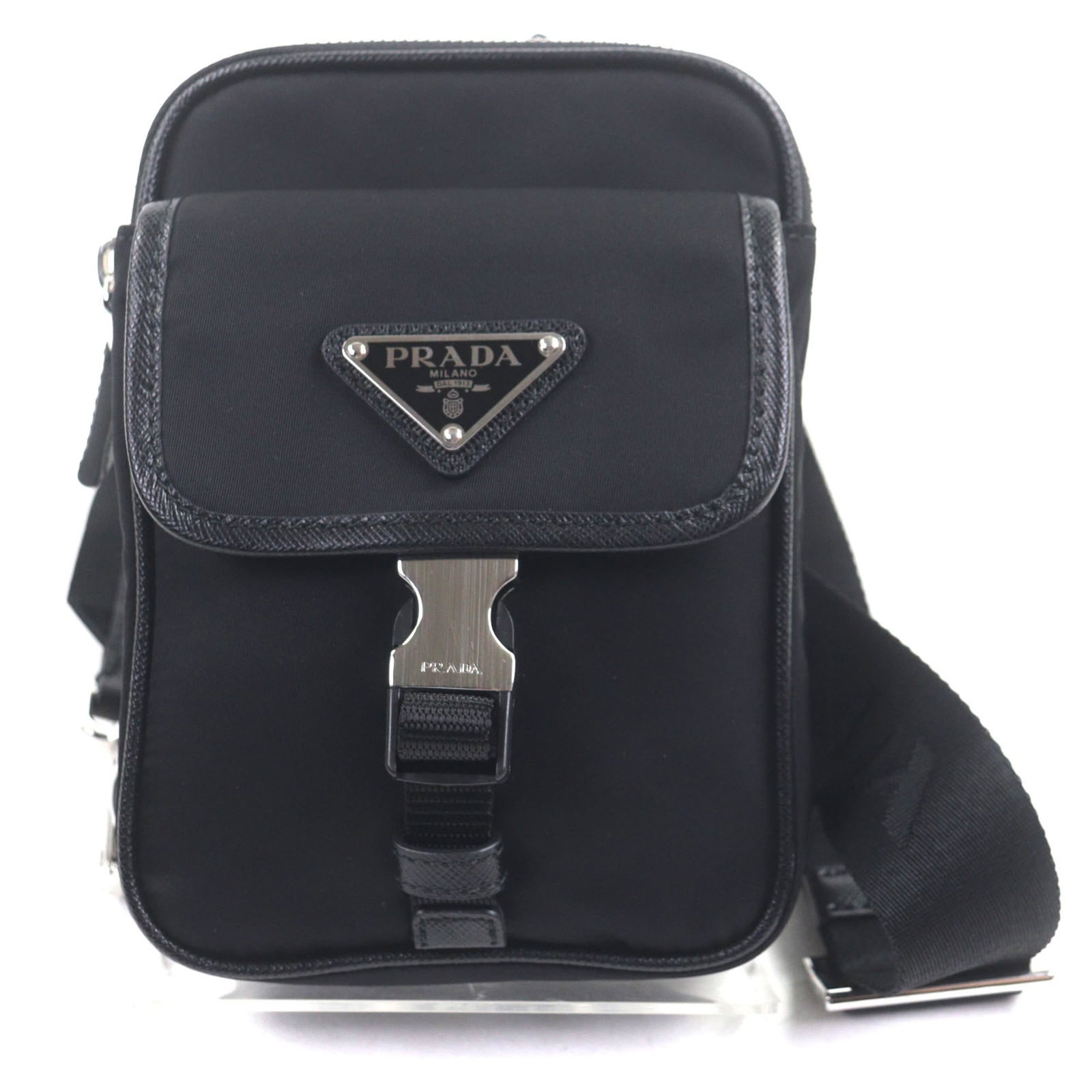 Sling Bag Saffiano Nylon Prada: Sling Bag Saffiano Nylon Prada Saffiano nylon Prada sling bag with silver hardware and a zipper closure, featuring a single zipper pocket for added convenience. Made from durable Saffiano material, th