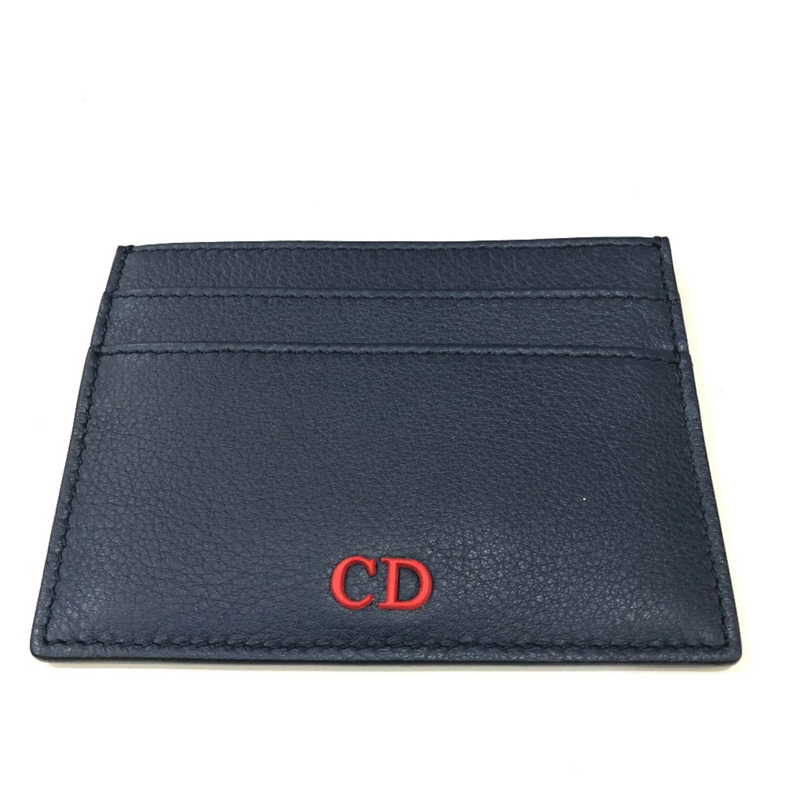 Card case leather Dior Homme: Card case leather Dior Homme Navy leather card case from Dior Homme, measuring 10cm x 7.5cm x 0.3cm. Made from high-quality leather, this card case features a classic design with a subtle navy color. 