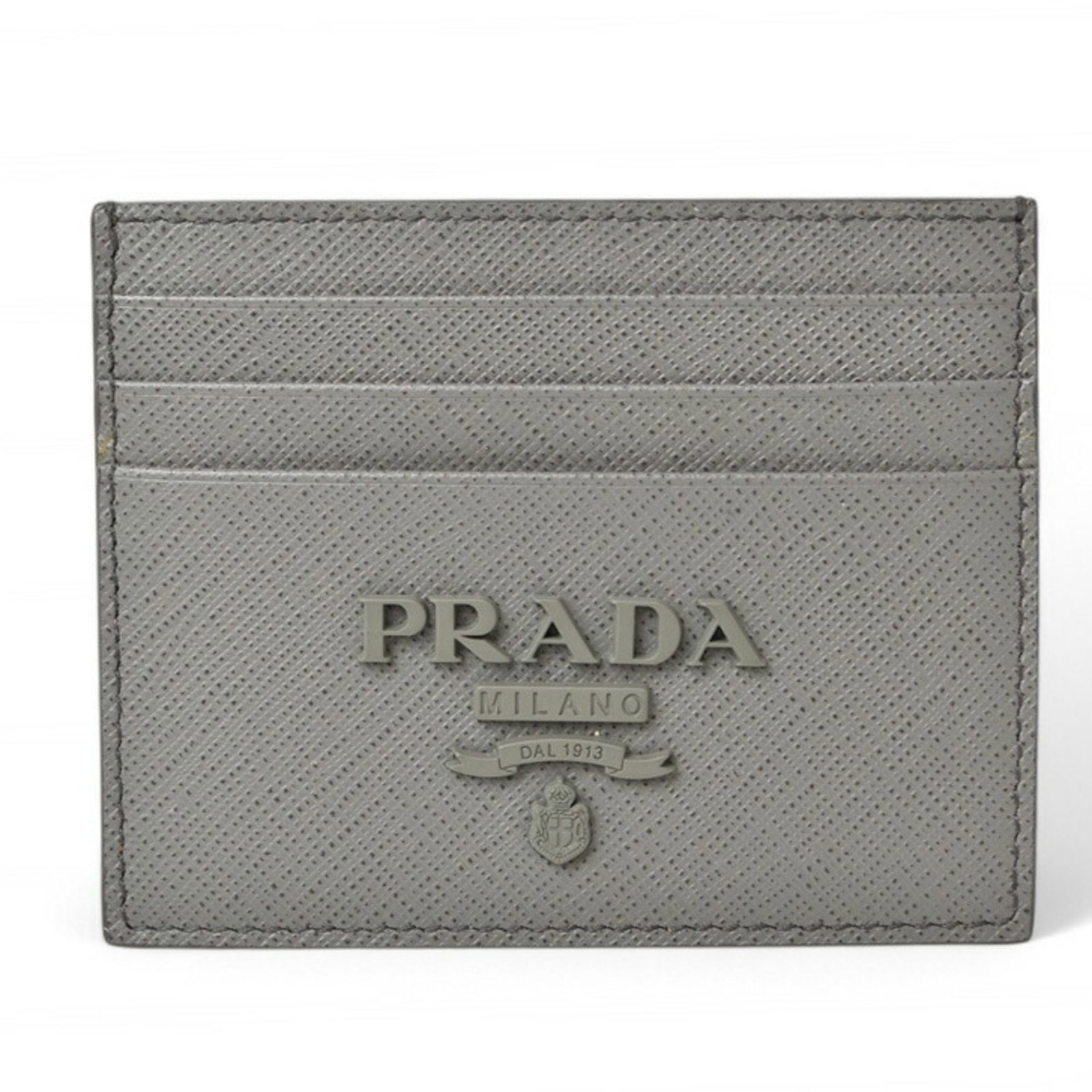 Card Case Saffiano by Prada: Card Case Saffiano by Prada Saffiano leather card case by Prada, crafted in light gray, features a compact 8cm x 10cm design. The card case comes in a sturdy box, providing a convenient way to store a