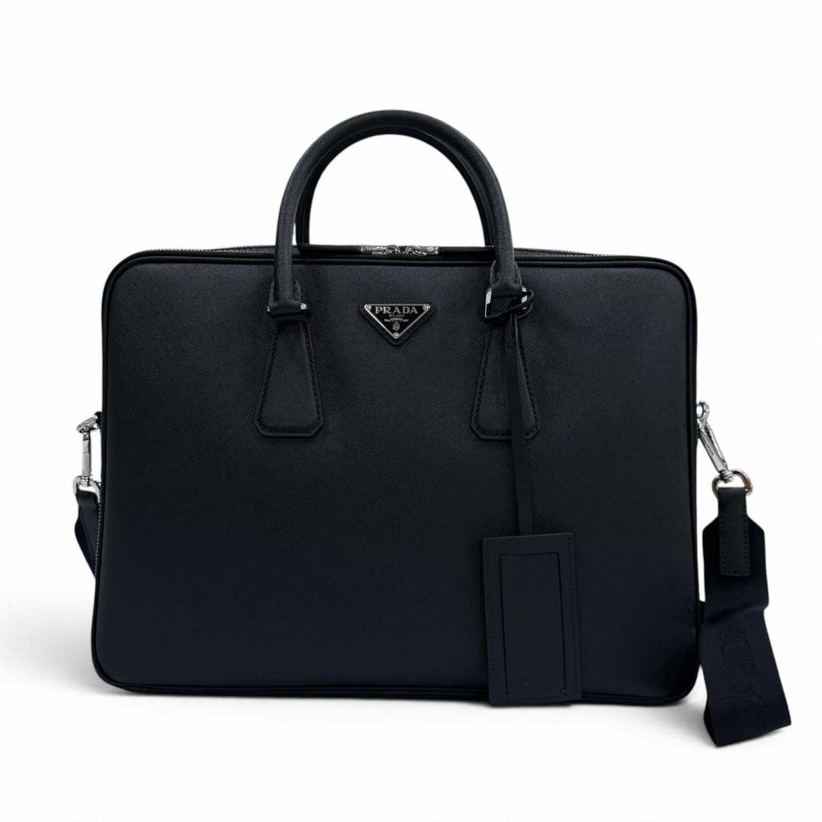 Briefcase Prada Leather: Briefcase Prada Leather Saffiano leather briefcase from Prada, featuring a sleek black design with a durable and water-resistant finish. Made with high-quality materials, this briefcase measures 28.5c