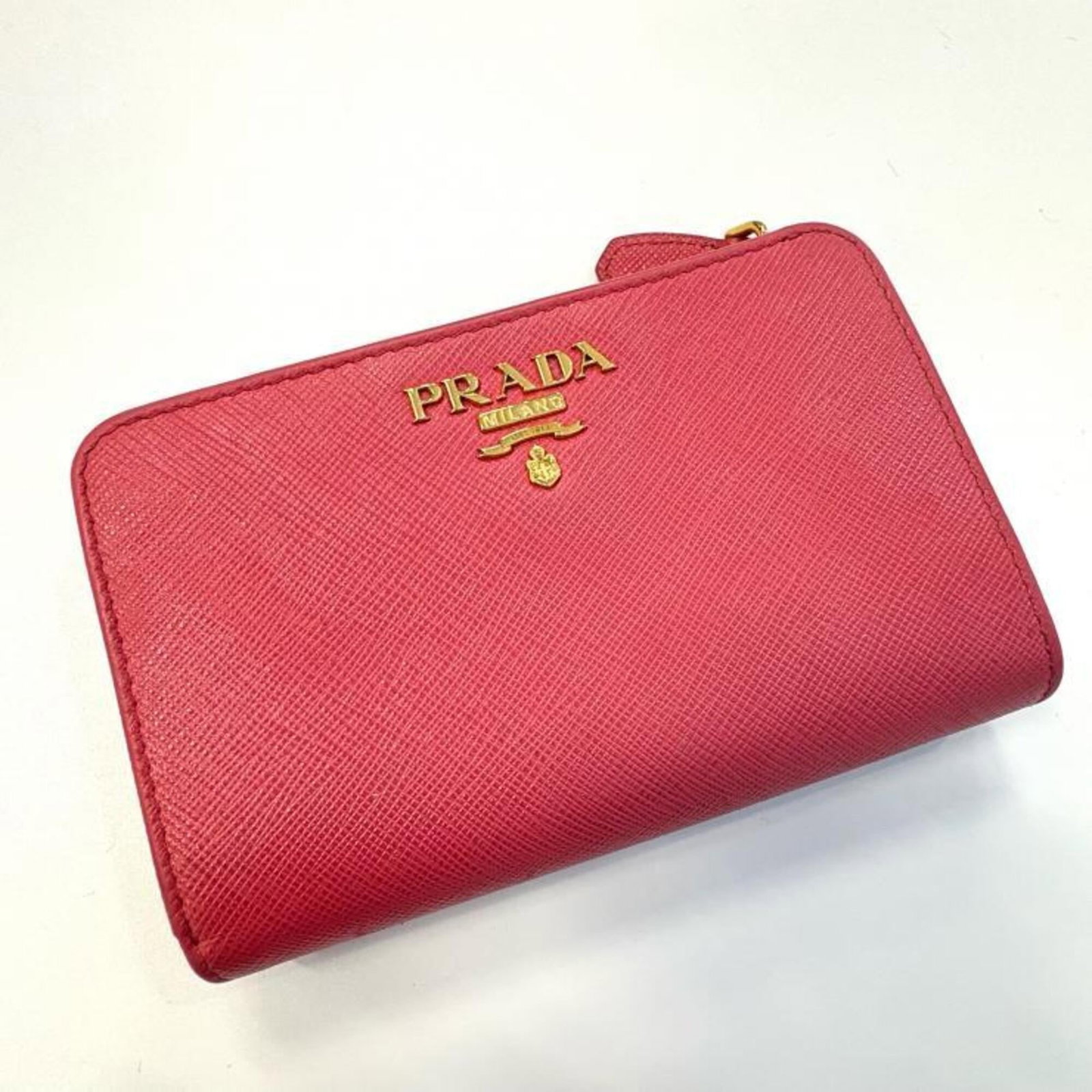 Saffiano Metal Bi fold Wallet: Saffiano Metal Bi fold Wallet Saffiano Metal Bi fold Wallet by Prada is a sleek and sophisticated accessory. Made from durable Saffiano Metal, this bi-fold wallet measures 9cm x 14.2cm x 2.7cm and fea