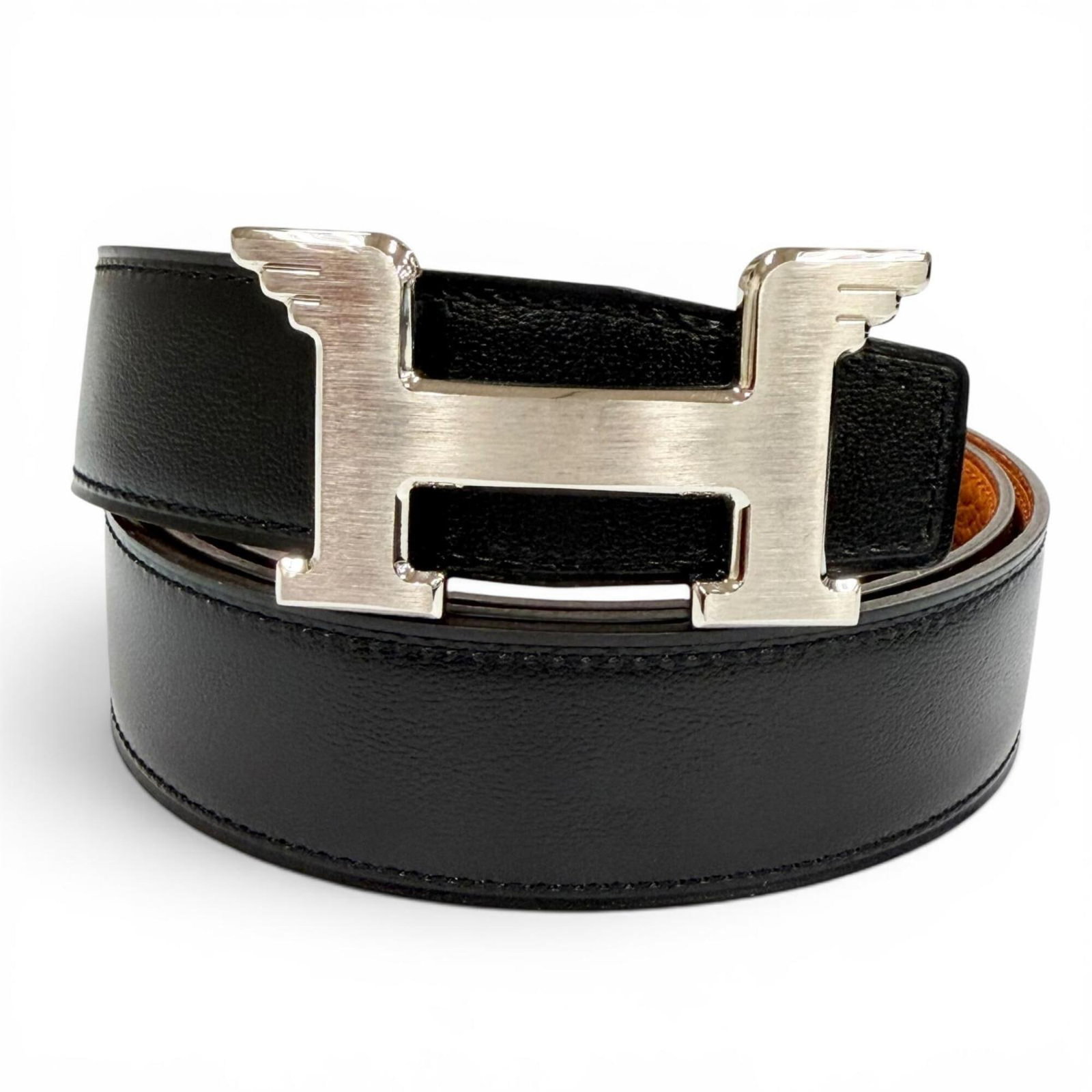 Hermes Standard Belt: Hermes Standard Belt Box calf leather and Togo leather combine in this classic standard belt from Hermes, available in black and orange. Measuring 107cm-112cm, it features a timeless design that