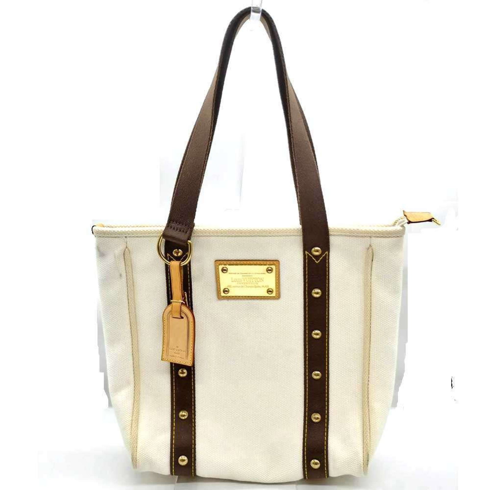Canvas Tote Louis Vuitton Handbag: Canvas Tote Louis Vuitton Handbag Canvas Tote in Brown, Ecru, and White, featuring gold hardware and an open style, this Louis Vuitton Antigua tote bag is a stylish and casual accessory for everyday