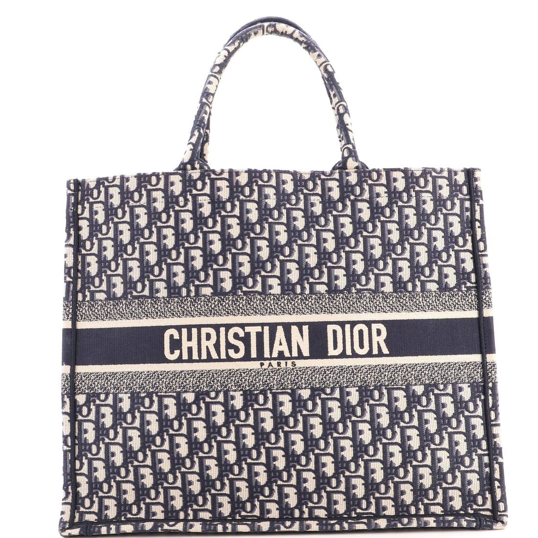 Christian Dior Oblique Canvas Large Tote Book: Christian Dior Oblique Canvas Large Tote Book Blue Oblique Canvas Large Tote Book by Christian Dior features a canvas exterior with heavy corner wear, scuffs, and minor discoloration. The interior is