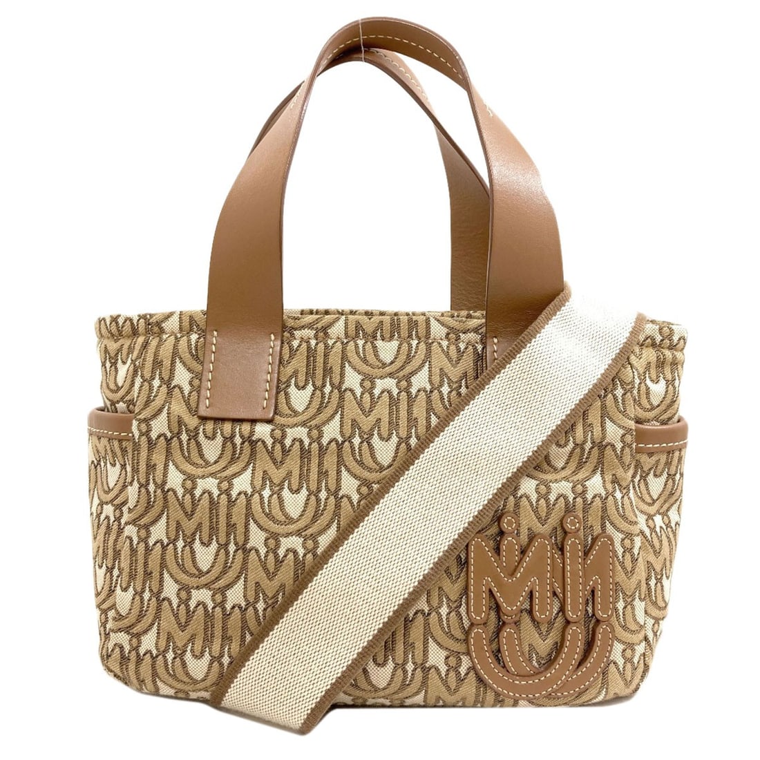 Logo Motif 2Way Handbag Canvas: Logo Motif 2Way Handbag Canvas Brown canvas handbag with a logo motif design, bearing a signature. Made from high-quality canvas, this 2-way handbag features a classic brown exterior color. The logo