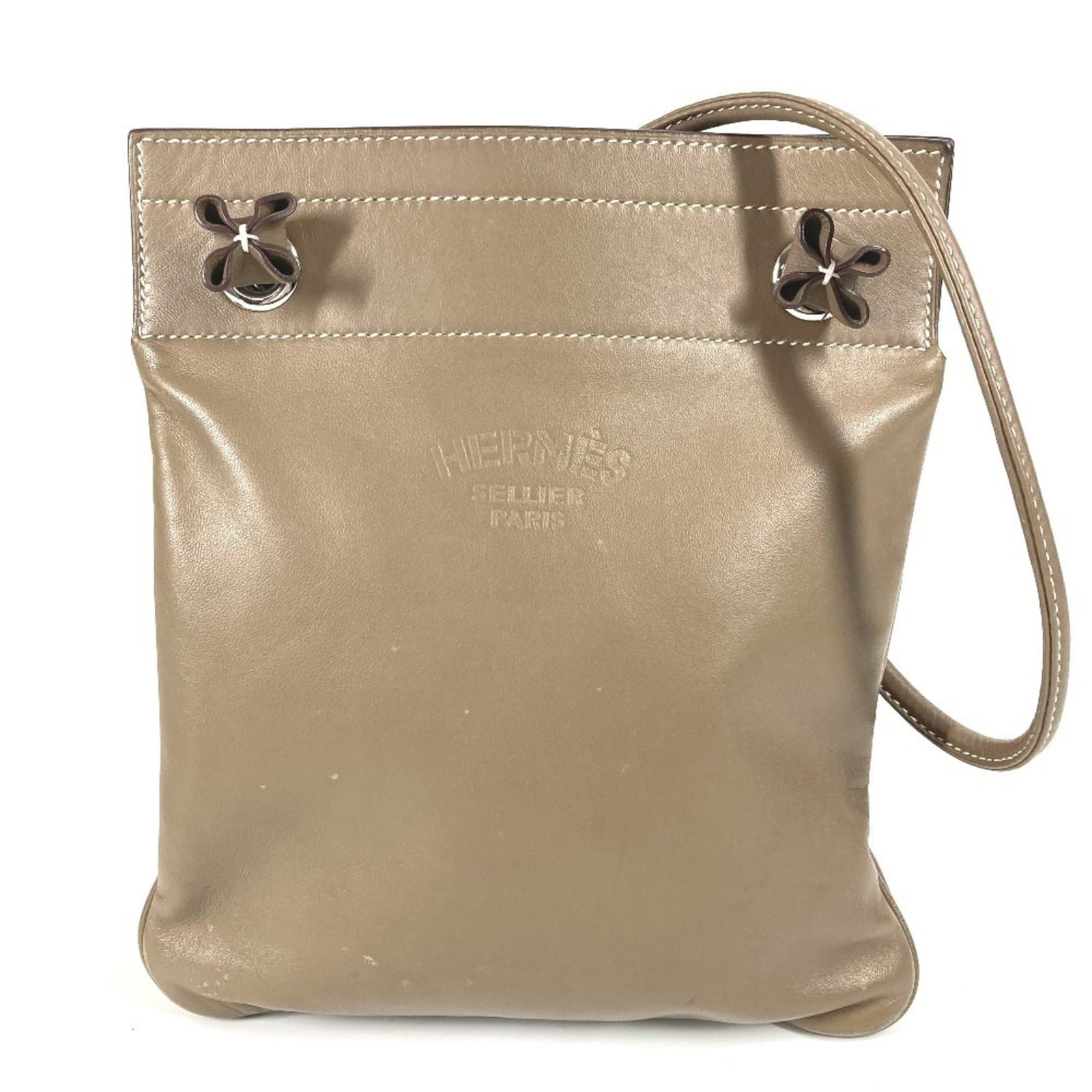 Hermes Pochette Leather Bag: Hermes Pochette Leather Bag Etoupe gray leather Pochette bag from Hermes, crafted with classic French design, features a timeless combination of style and sophistication. The bag's clean lines and
