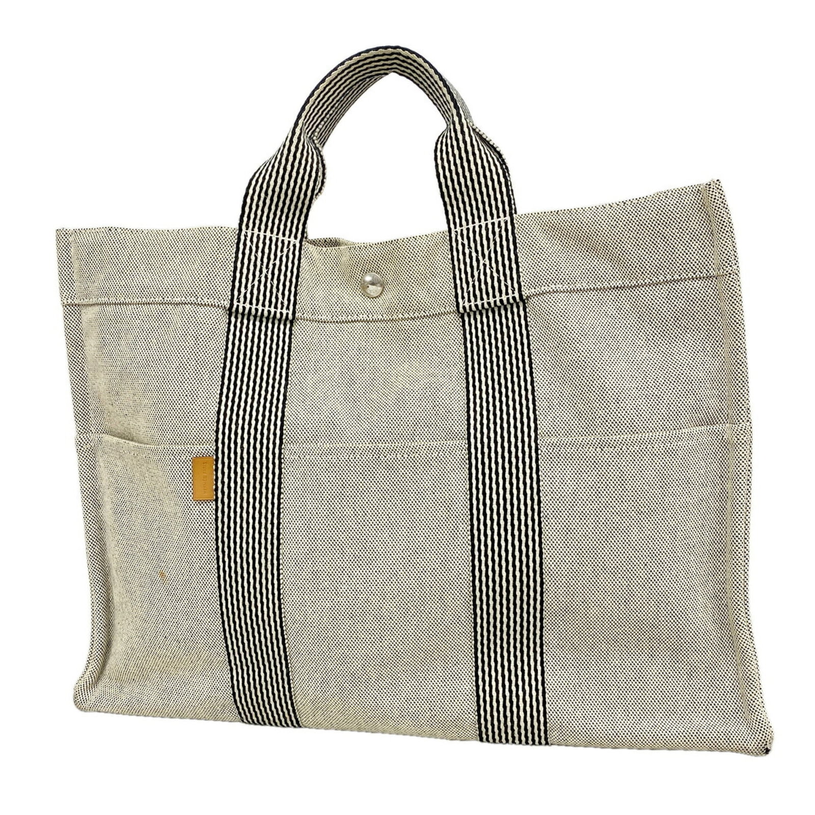 Canvas tote bag Hermes: Canvas tote bag Hermes Canvas tote bag from Hermes, made from high-quality canvas material in a sleek black color, features silver hardware for a sophisticated look. The bag measures 31cm x 42.5cm x 1