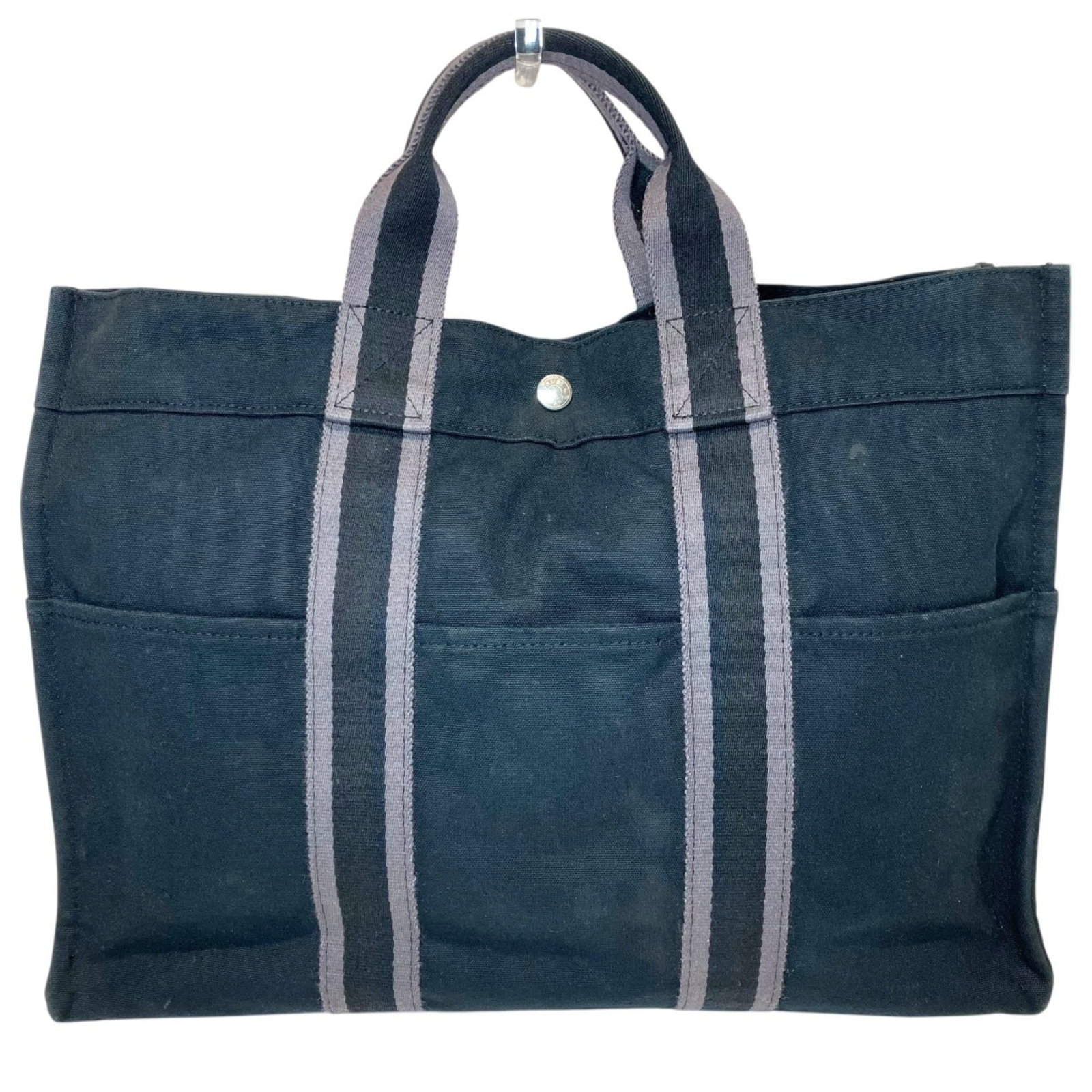 Canvas tote bag Hermes: Canvas tote bag Hermes Canvas tote bag from Hermes, available in black and gray, features a 30cm x 42cm x 10cm size. Made from canvas material, this tote bag bears a signature. The bag's classic