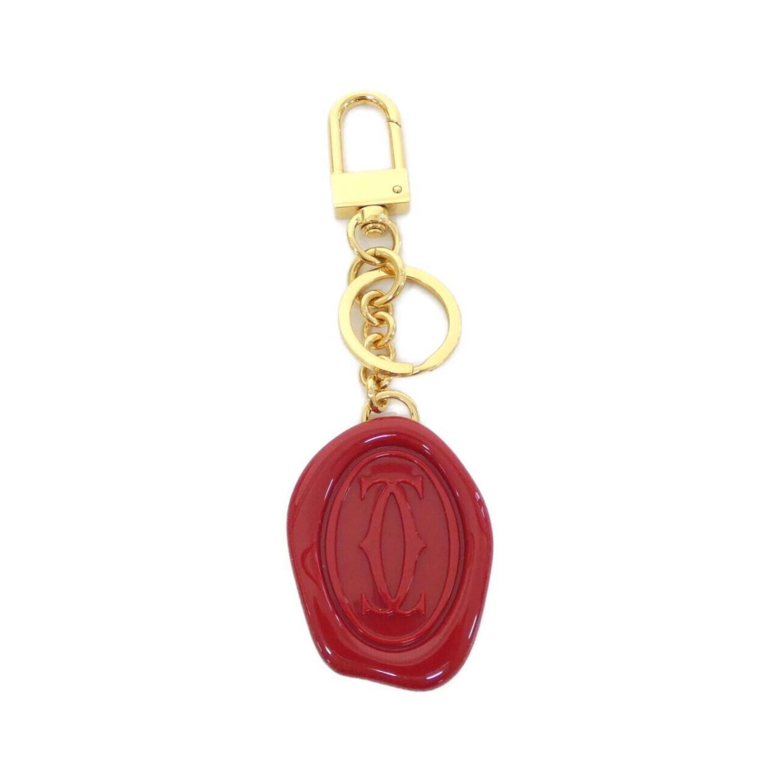 Keyring by Cartier: Keyring by Cartier Gold and red hues add a touch of elegance to this Cartier keyring, a stylish accessory that complements any outfit. The keyring's design is characterized by its classic style,