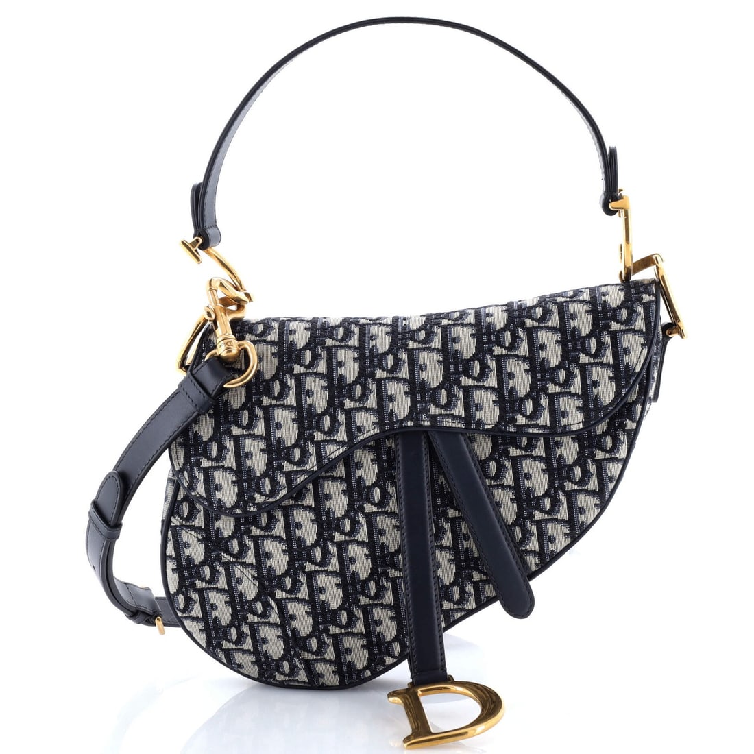 Saddle Handbag Strap Oblique Canvas Medium Christian Dior: Saddle Handbag Strap Oblique Canvas Medium Christian Dior Saddle Handbag with Strap Oblique Canvas Medium in Blue. This Christian Dior shoulder bag features a striking oblique canvas design and a