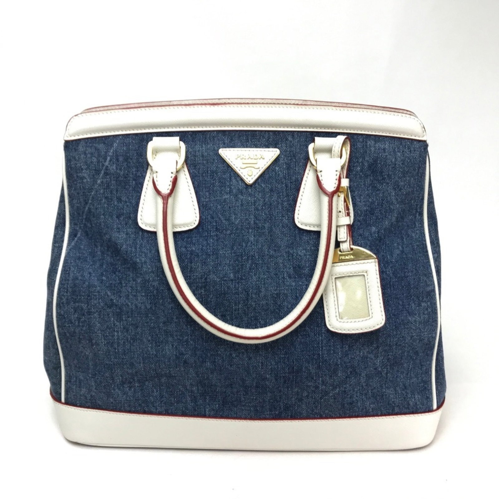 Prada Handbag Denim Leather: Prada Handbag Denim Leather Denim leather Prada handbag with a blue and white color scheme, featuring a zipper closure and two zipper pockets, plus an open pocket. Measuring 29cm x 32cm x 15cm, this