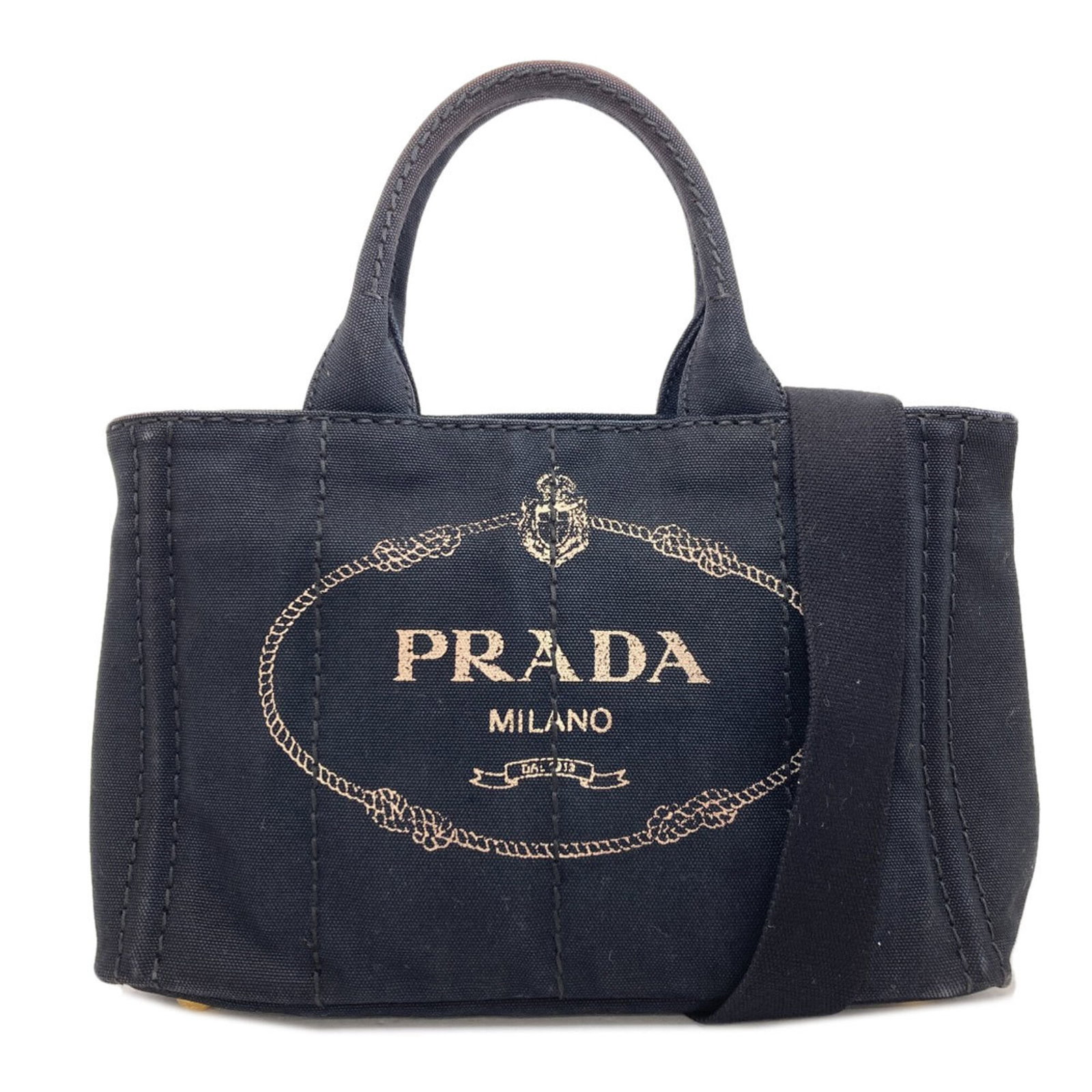 Handbag Canvas by Prada: Handbag Canvas by Prada Canvas by Prada is a black handbag made from canvas material, measuring 19cm x 29cm x 16cm. This iconic design bears a signature, adding a touch of elegance to its sleek and mo