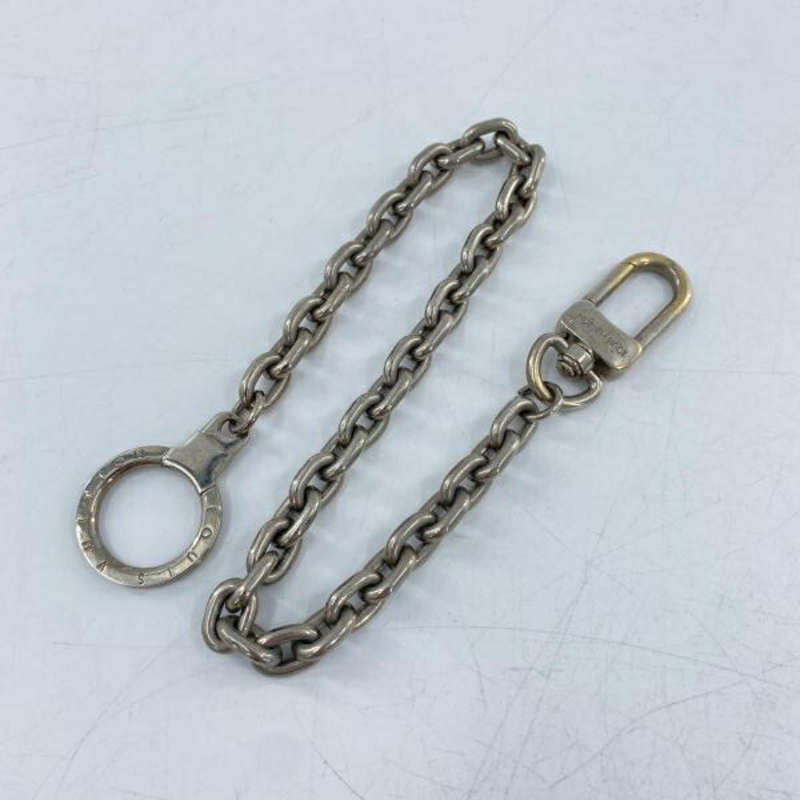 M65076 Louis Vuitton Sienne Ancre Silver Keyring Keychain: M65076 Louis Vuitton Sienne Ancre Silver Keyring Keychain Silver chain and strap length of 39.5cm. This Louis Vuitton Sienne Ancre keyring features a sleek and modern design. The item bears a signatur