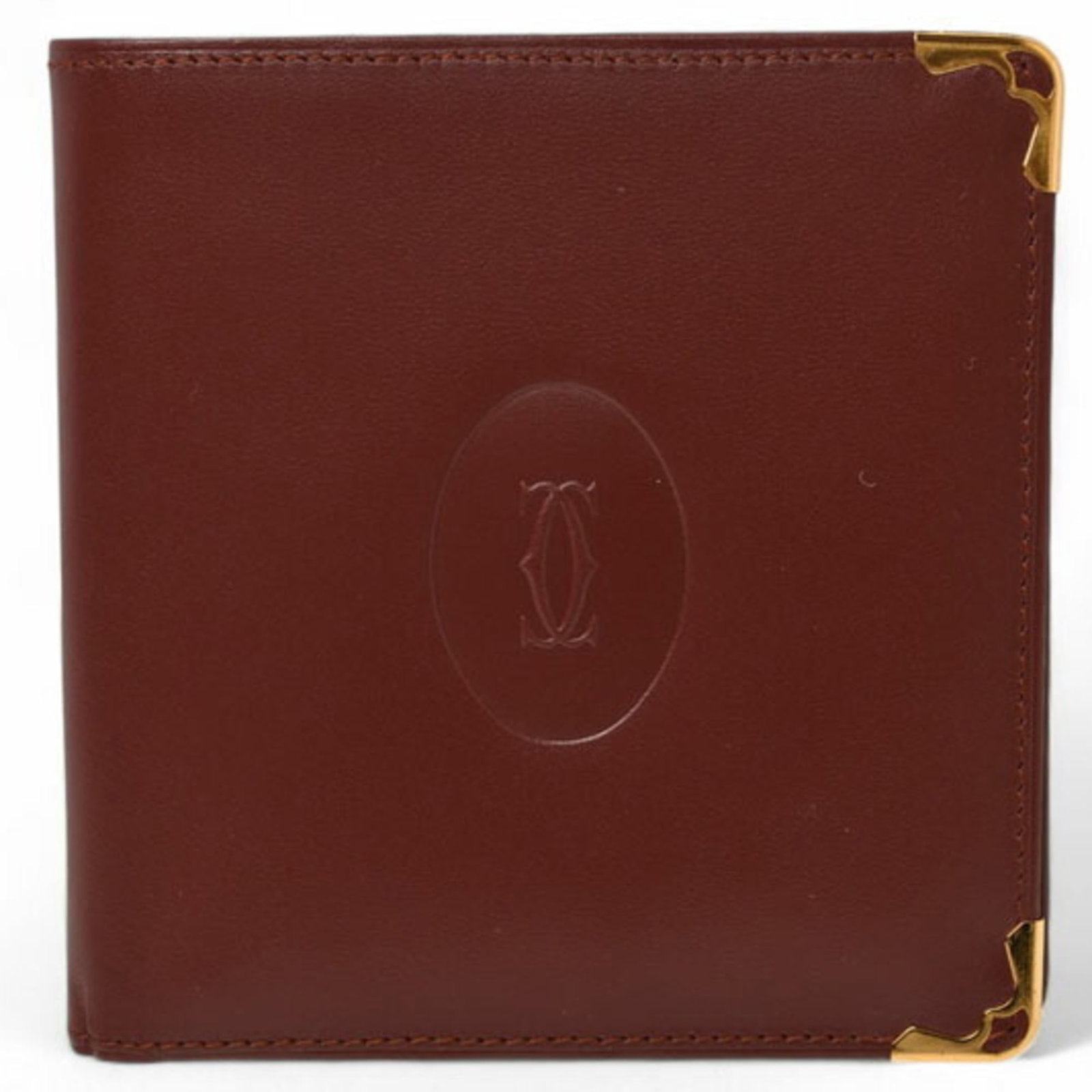 Bi Fold Cartier Wallet: Bi Fold Cartier Wallet Bordeaux leather, a rich and sophisticated color, is used in the construction of this bi-fold Cartier wallet, which measures 10.2cm x 10.5cm x 1.5cm. The open, snap fastener clo