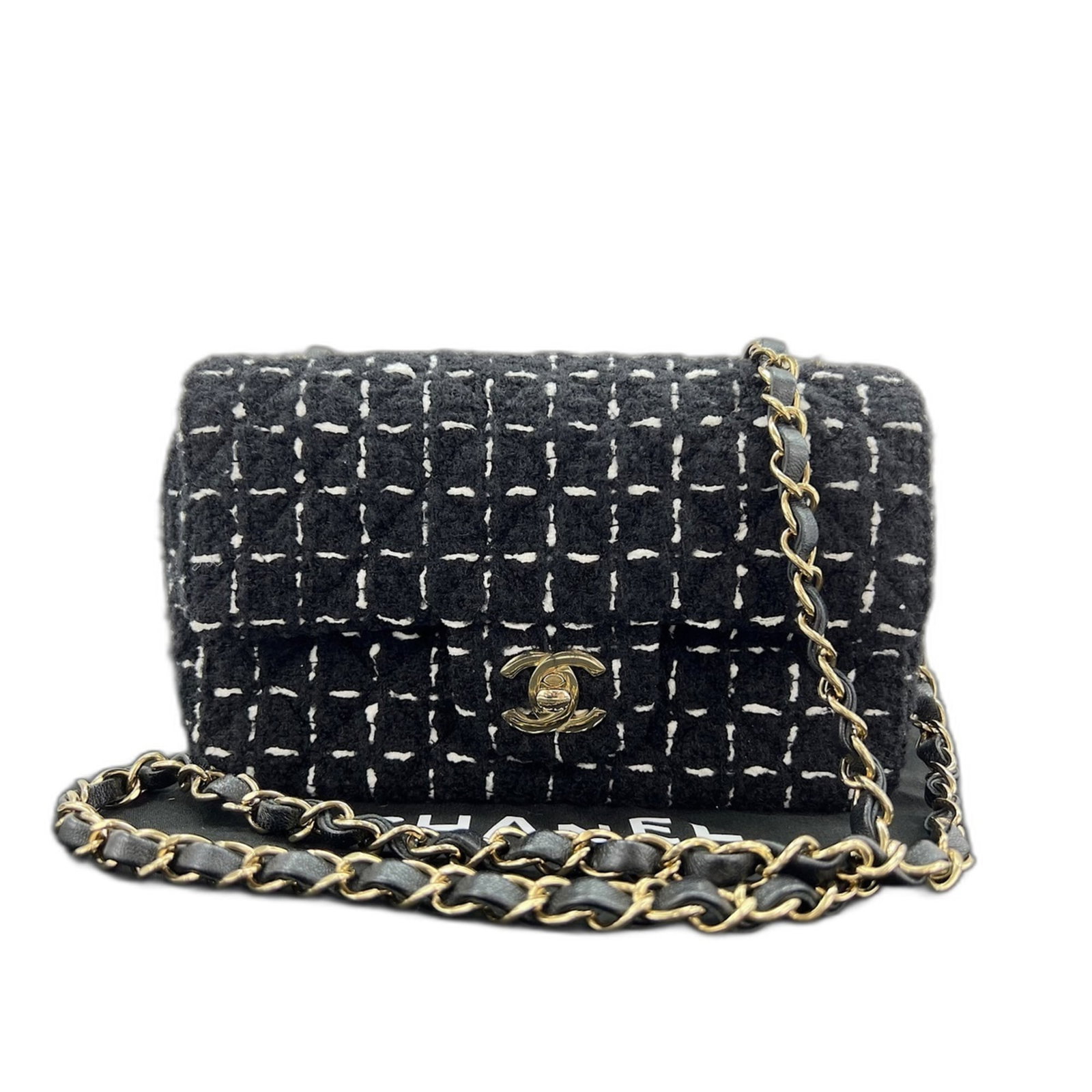 Tweed shoulder bag by Chanel: Tweed shoulder bag by Chanel Tweed shoulder bag by Chanel features a classic design with a timeless black color and a structured shape. Made from high-quality tweed material, this bag is a stylish acc
