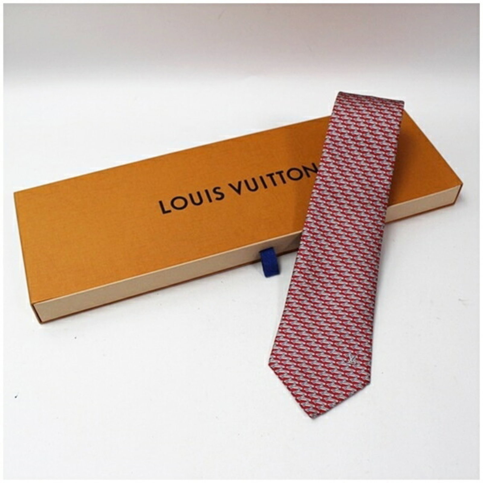 Vuitton Cravat Silk Louis: Vuitton Cravat Silk Louis Silk cravat with a distinctive Louis Vuitton design, available in gray and red colors, featuring a width of 8cm. This cravat is made from high-quality silk and showcases the