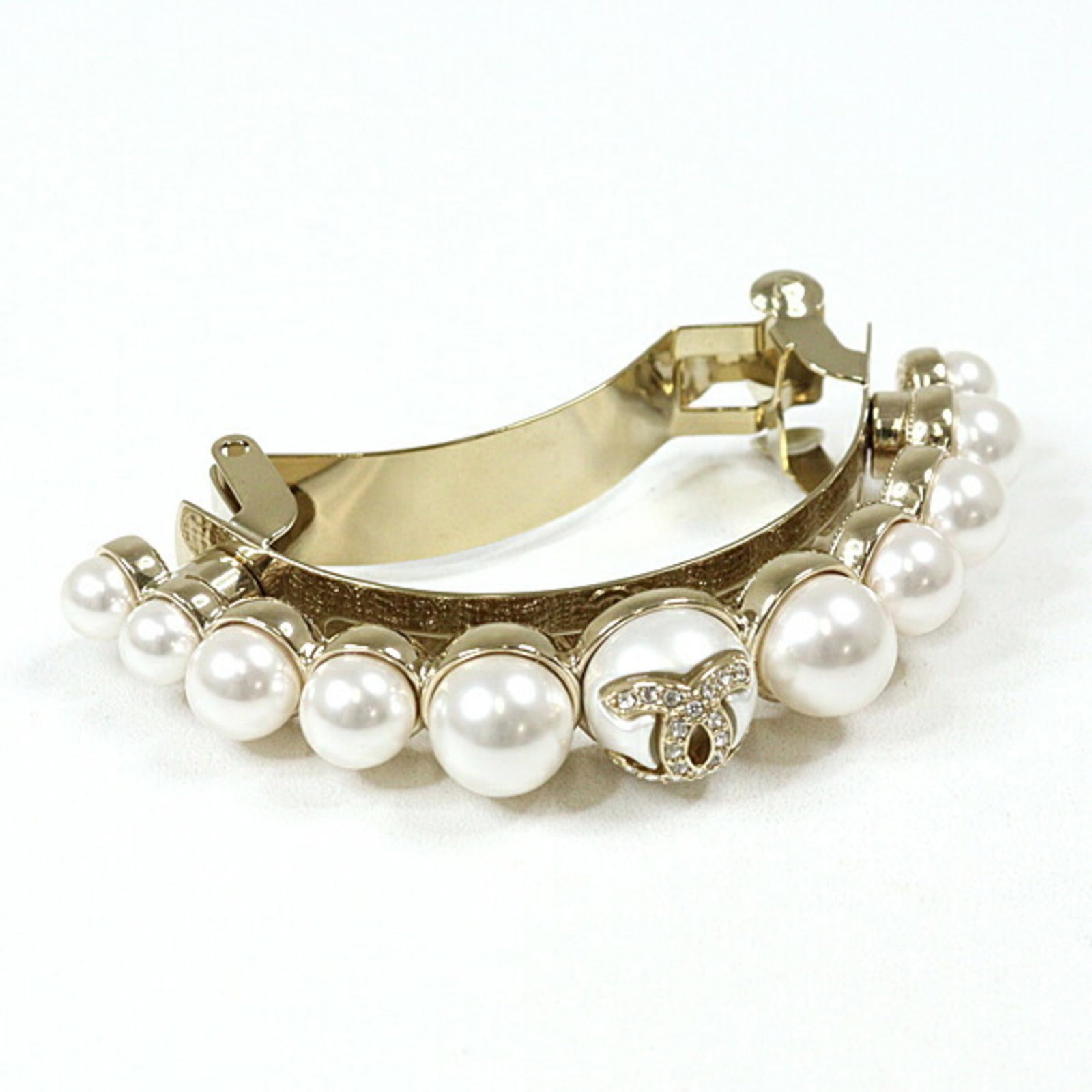 Metal Rhinestone Barrette Chanel: Metal Rhinestone Barrette Chanel Metal Rhinestone Barrette Chanel is a gold and white metal barrette adorned with rhinestones, measuring 4cm x 7.5cm. This piece comes in a box, providing a convenient 
