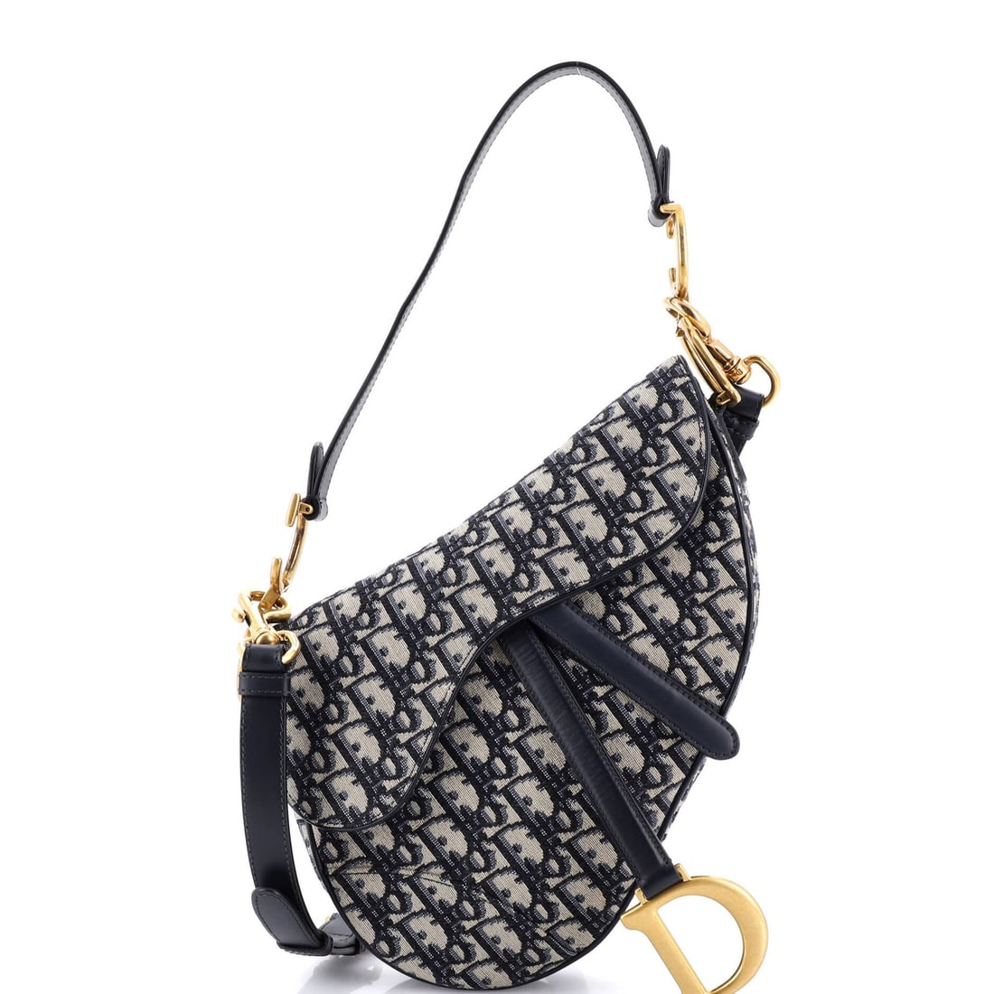 Saddle Handbag Strap Oblique Canvas Medium Christian Dior: Saddle Handbag Strap Oblique Canvas Medium Christian Dior Saddle Handbag with Strap Oblique Canvas Medium in Blue. This Christian Dior shoulder bag features a striking oblique canvas design and a stur