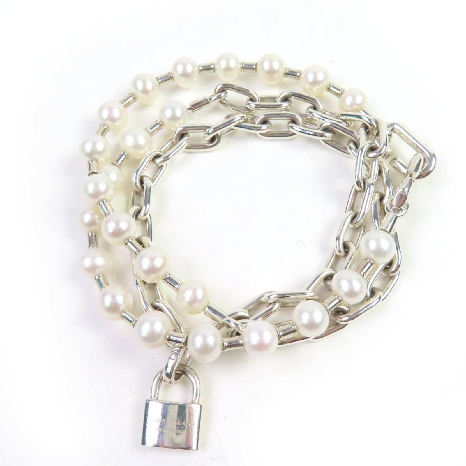 TIFFANY Charm Bracelet Silver 925: TIFFANY Charm Bracelet Silver 925 Silver 925 Tiffany charm bracelet with a beautiful pearl stone, featuring a classic and elegant design. The 17cm long bracelet is gently used with minor signs of