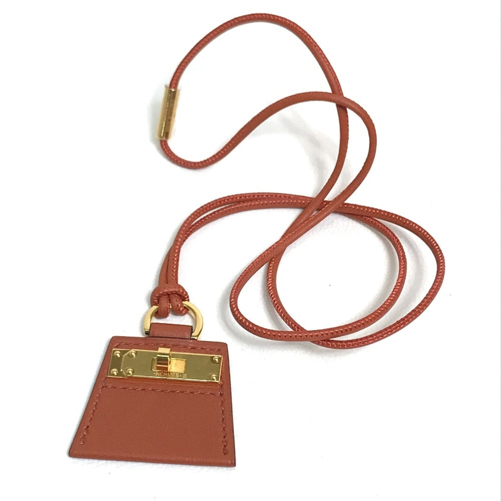 HERMES Leather Brown: HERMES Leather Brown The Hermes Leather Brown necklace boasts a rich, brown leather pendant, measuring 32mm x 40mm, perfectly complemented by a 36cm chain circumference. This elegant accessory comes i
