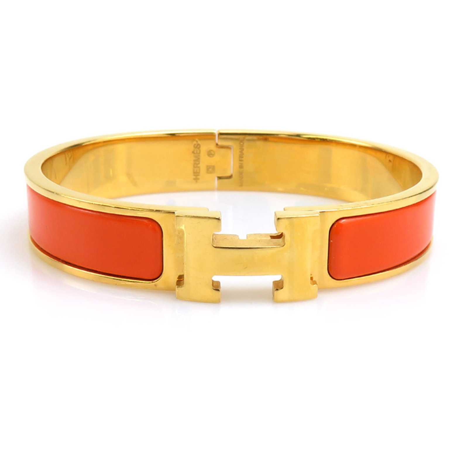 HERMES Bangle Enamel Metal: HERMES Bangle Enamel Metal Gold and orange enamel metal bangle from the iconic French fashion house Hermes, bearing a signature. This 17cm bangle features a classic design with visible wear and scratc