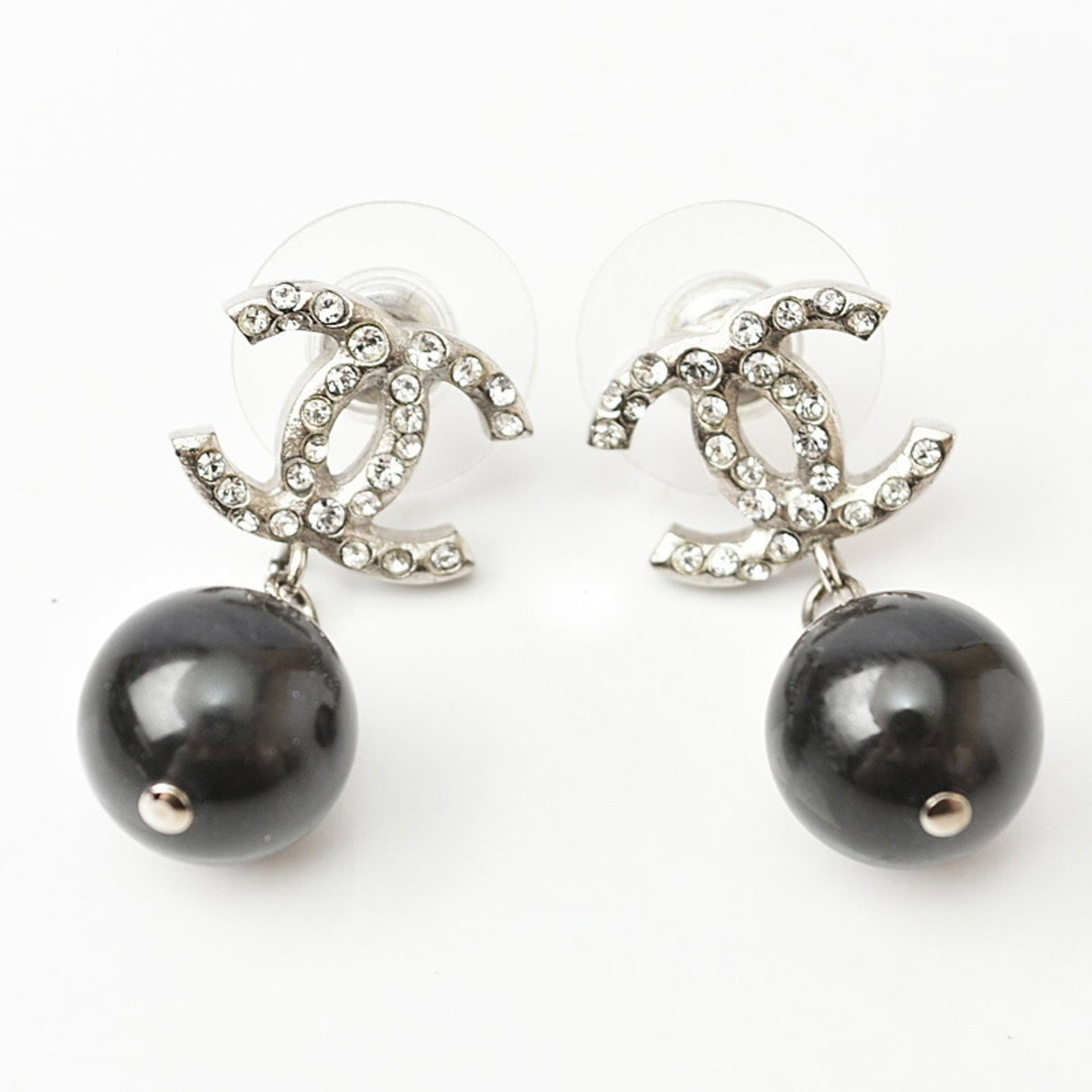 CHANEL Stud Earrings Metal Rhinestone: CHANEL Stud Earrings Metal Rhinestone Stud earrings featuring metal and rhinestone details, in black and silver finishes. The Chanel brand is evident in the design, with a classic style that exudes