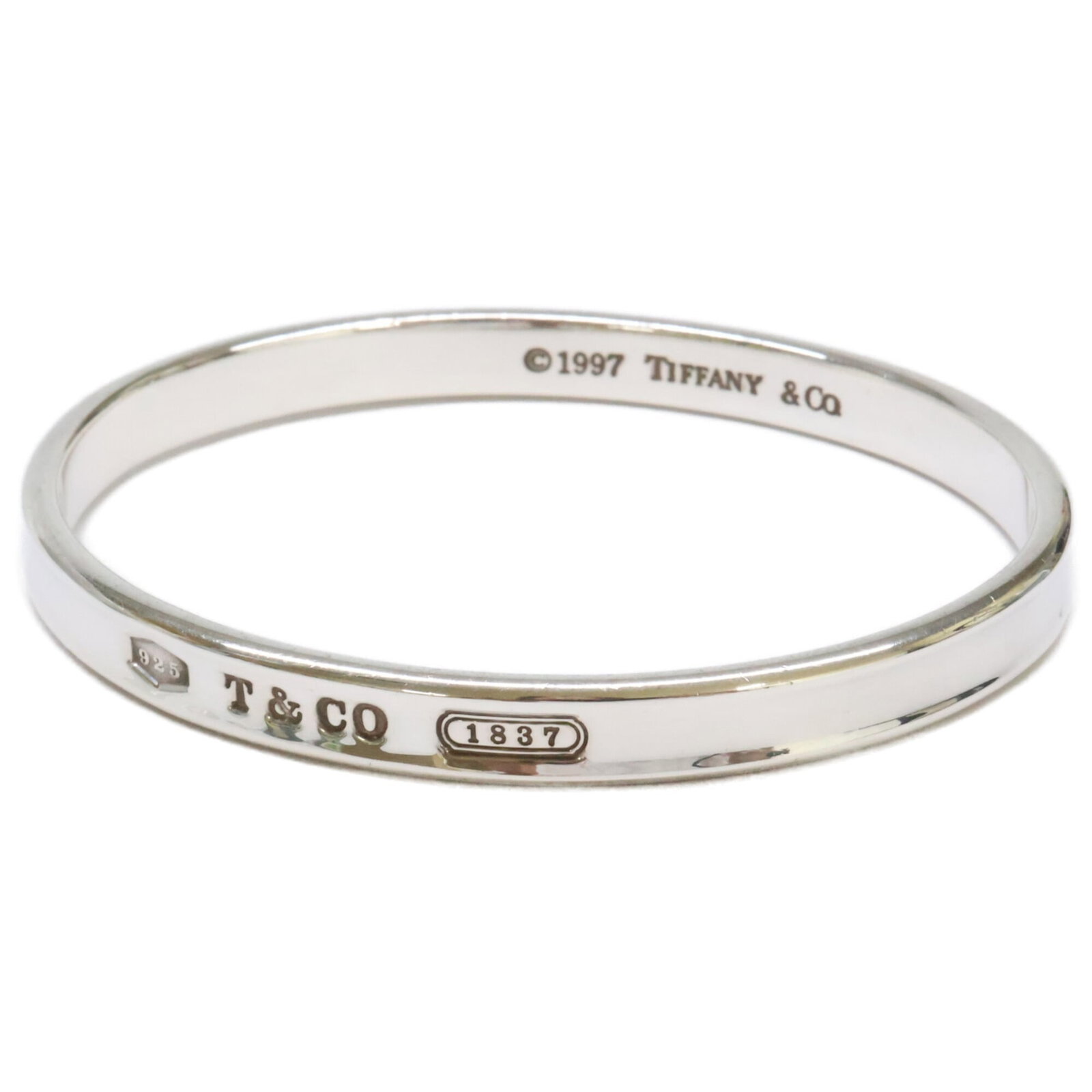 TIFFANY Bangle Silver 925: TIFFANY Bangle Silver 925 Silver 925 bangle from Tiffany, measuring 19.5cm in length, features a classic design with visible wear and scratches. The item is made from genuine silver and bears a signat