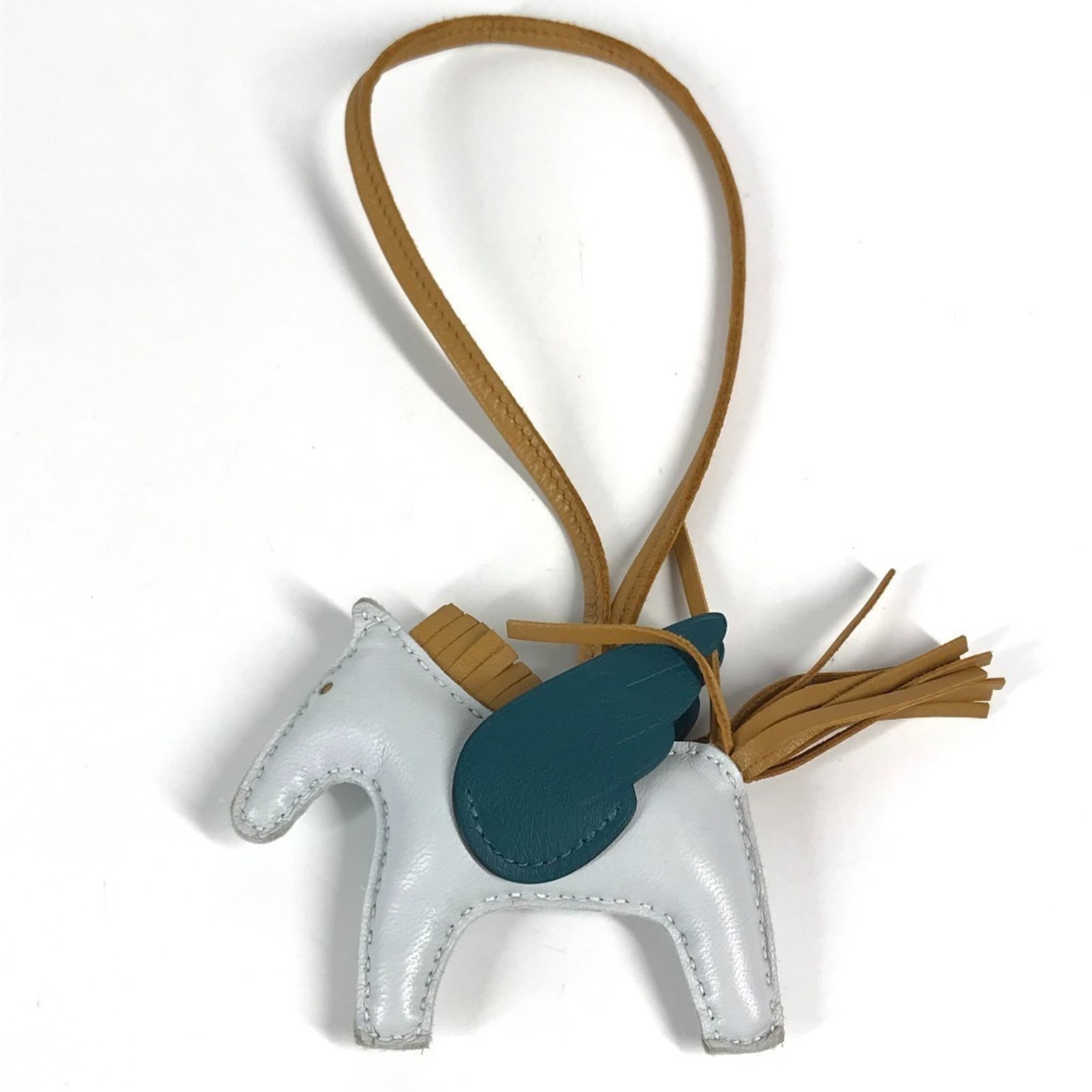 HERMES Handbag Charm Agneau Milo: HERMES Handbag Charm Agneau Milo Agneau Milo is a high-quality material used in the construction of this Hermes handbag charm. The beige and blue color options add a touch of elegance to any